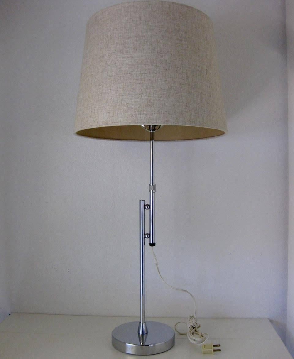 Mid-Century Modern era chrome-finished adjustable table lamp. The lamp and finial are original and vintage, with new shade. Beautiful, simple design of two chromed poles attached by chromed orbs. The lamp can adjust from 26