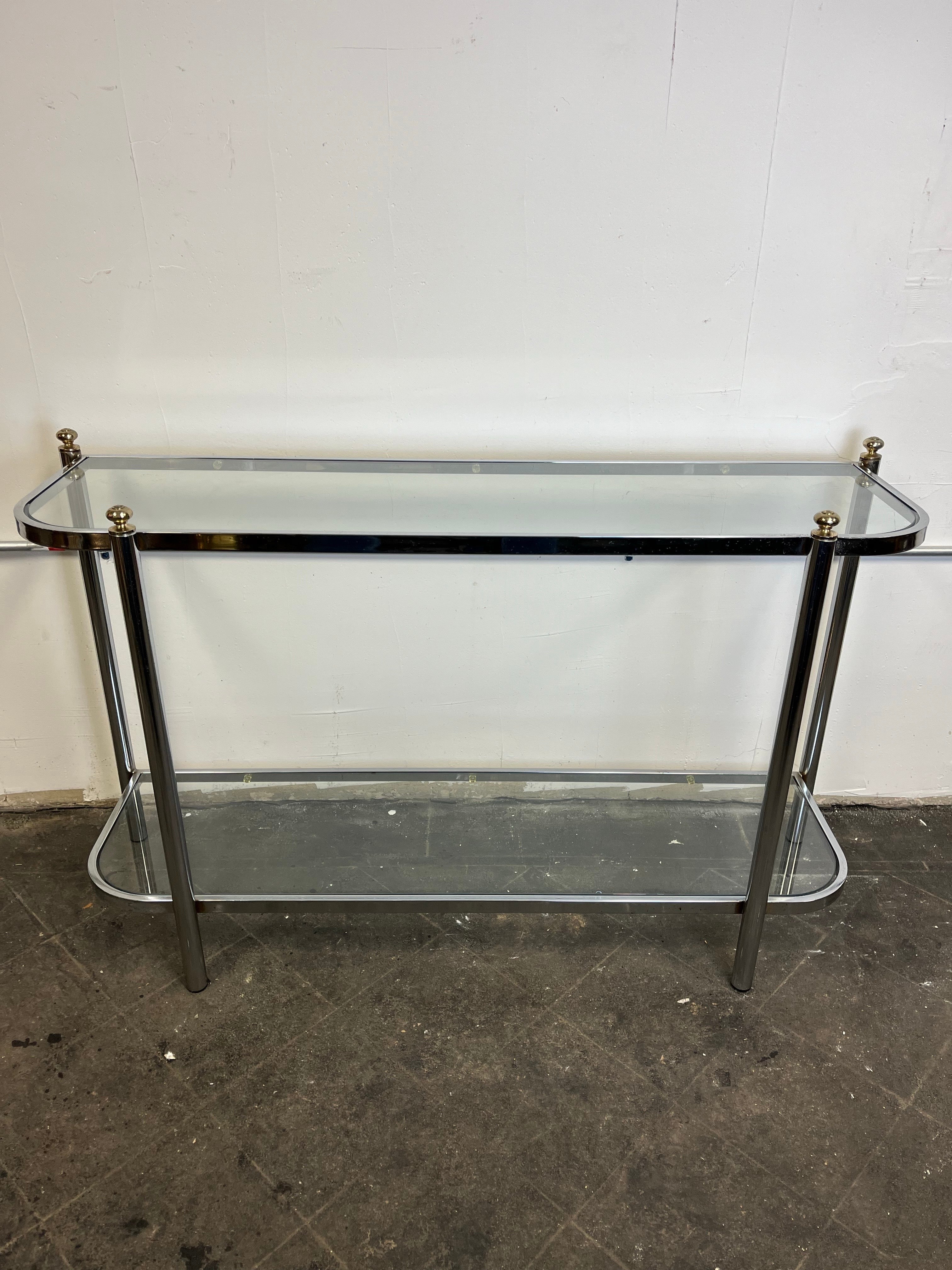 Consolle o tavolo da divano in ottone, cromo e vetro, con angoli arrotondati e due superfici in vetro. Linee classiche e contrasto. Gli angoli con finial a sfera completano un'atmosfera elegante e attuale. 
Curbside to NYC/Philly $450