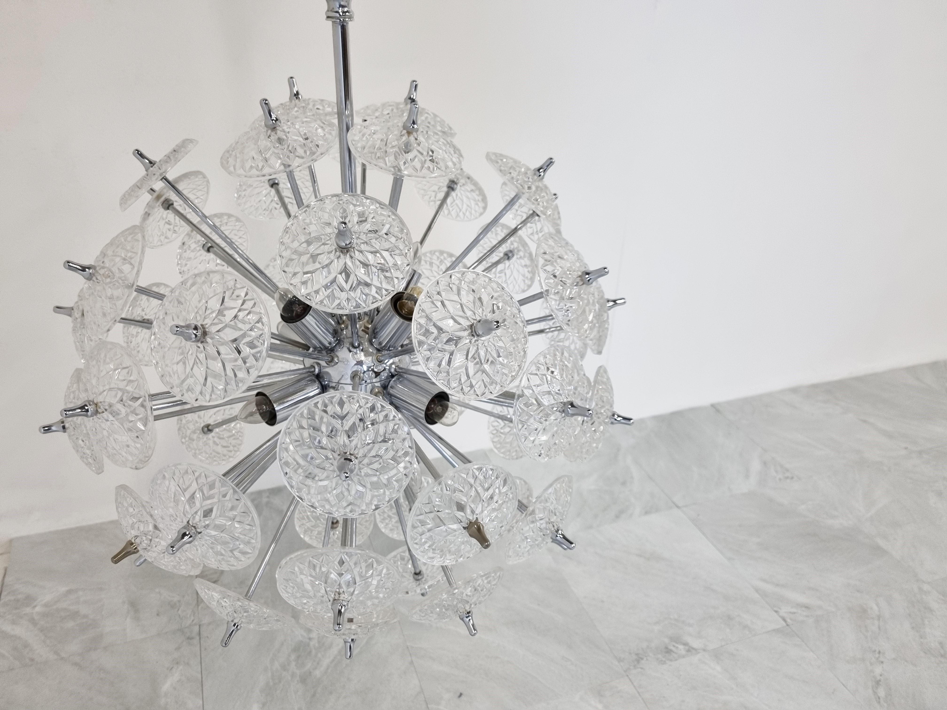 Impressive chrome and crystal sputnik chandelier.

The crystals are made by the renowned belgium glass company Val Saint Lambert.

The chandelier has 12 lightpoints that can be used with regular E14 candle light bulbs.

These chandeliers are