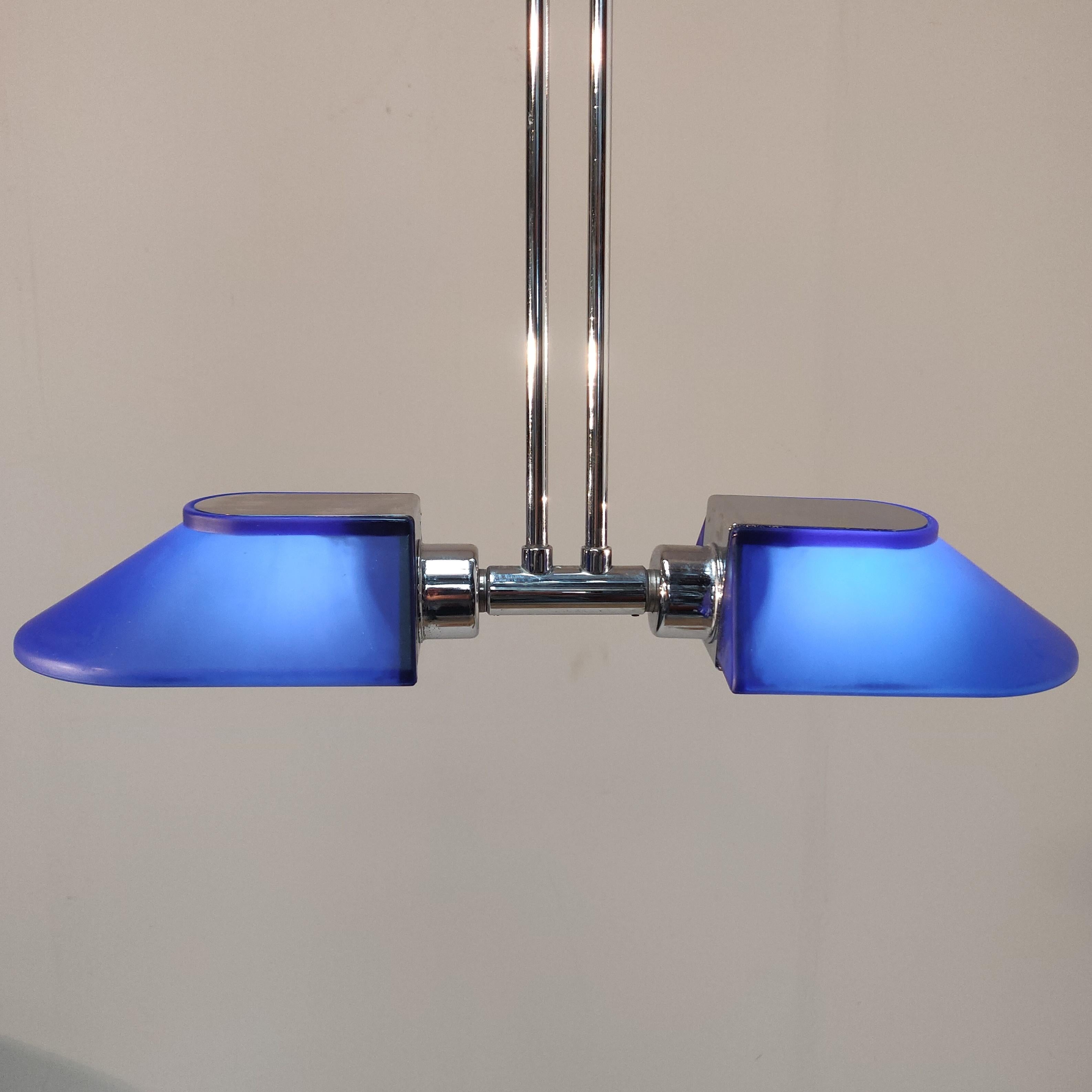 A Wonderfull pendant by Hustadt Leuchten with blue frosted rotatable glass shades and chromed in length adjustable 85-160 cm shaft.
The height is adjustable between 85 and 160 cm, the shades and its holder are 46 x 13 x 7 cm.
The combination of