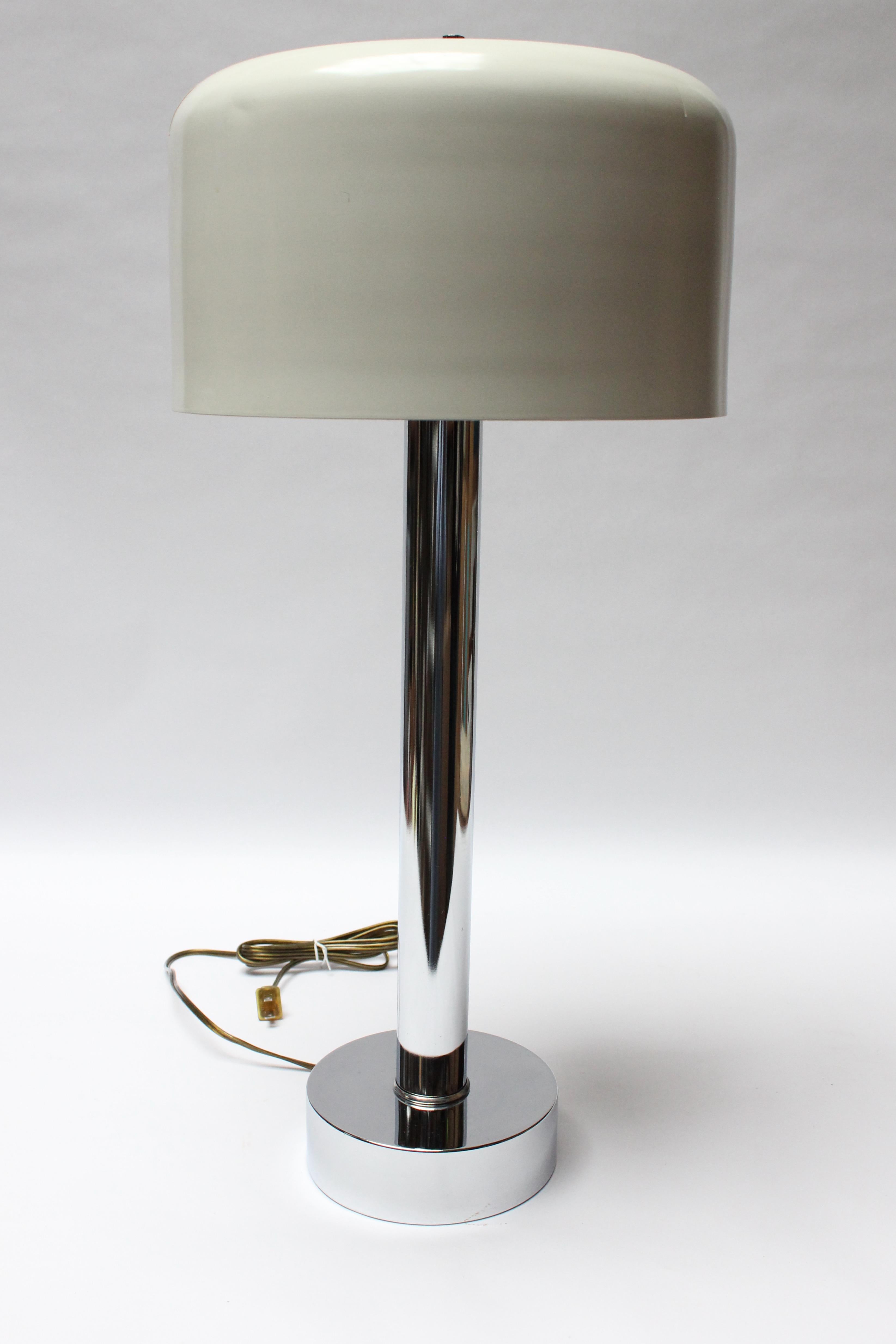 Vintage table lamp composed of a tubular chrome pillar supported by a round base with the original white lacquered shade. Similar to the 'Coupe' design by the Italian designer, Joe Colombo, the shade is lacquered aluminum with two slits reflecting