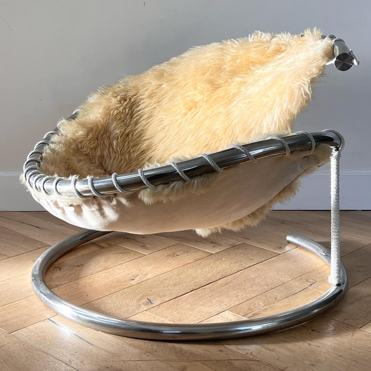 A incredibly unique mid century modern chrome swirl and sheepskin statement chair, circa late 1960s. A chrome spiral forms the frame of the piece, whilst wrapped rope comprises the setting for which thick sheepskin sits to create a sumptuous (and