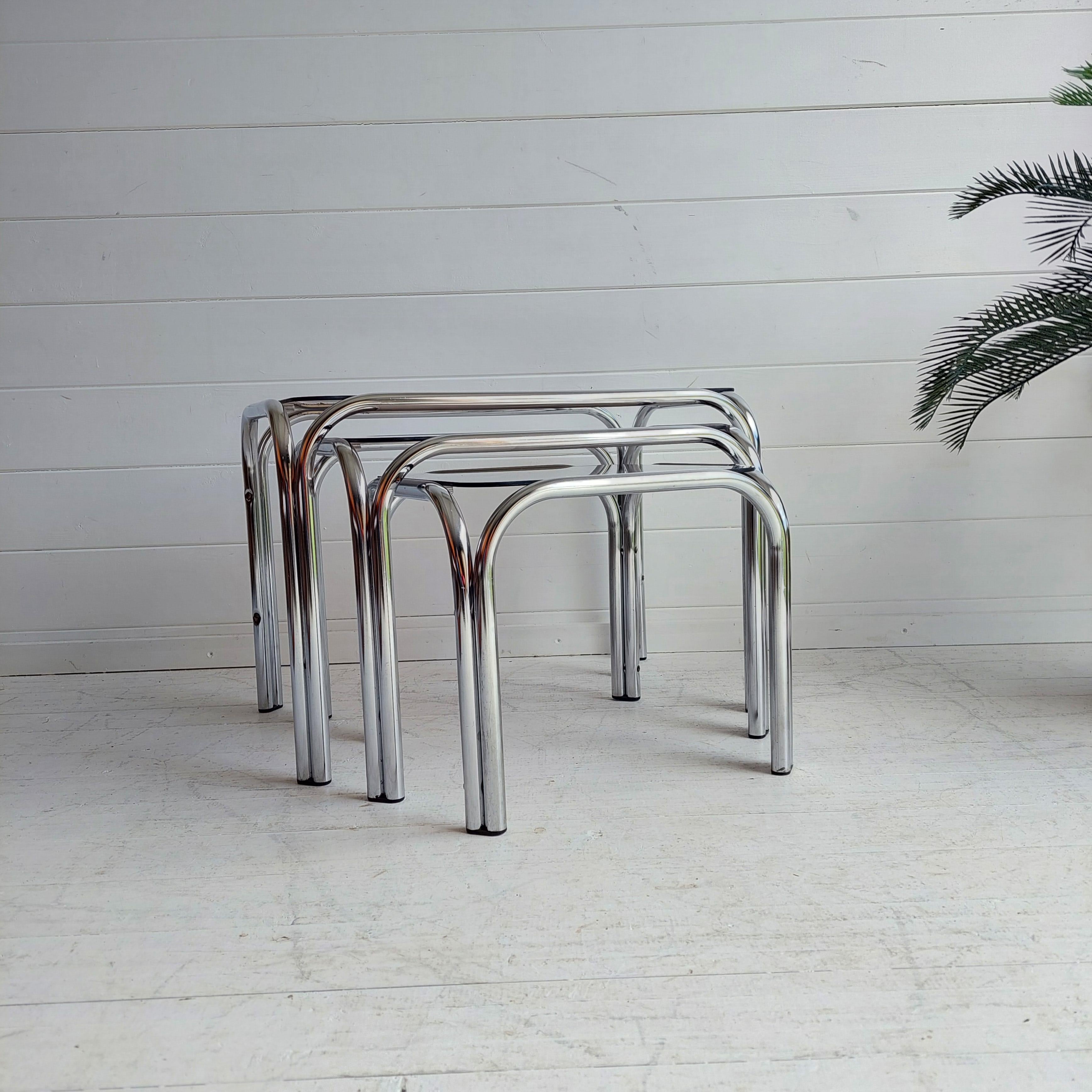 Nesting tables with glass on the tables tops
Chrome metal tubes, 1970s
Space Age chrome smoked glass side table set. 
A beautiful and modern of 3 vintage nesting tables in chrome color. 
All tables have a nice orginal smoked glass top with round