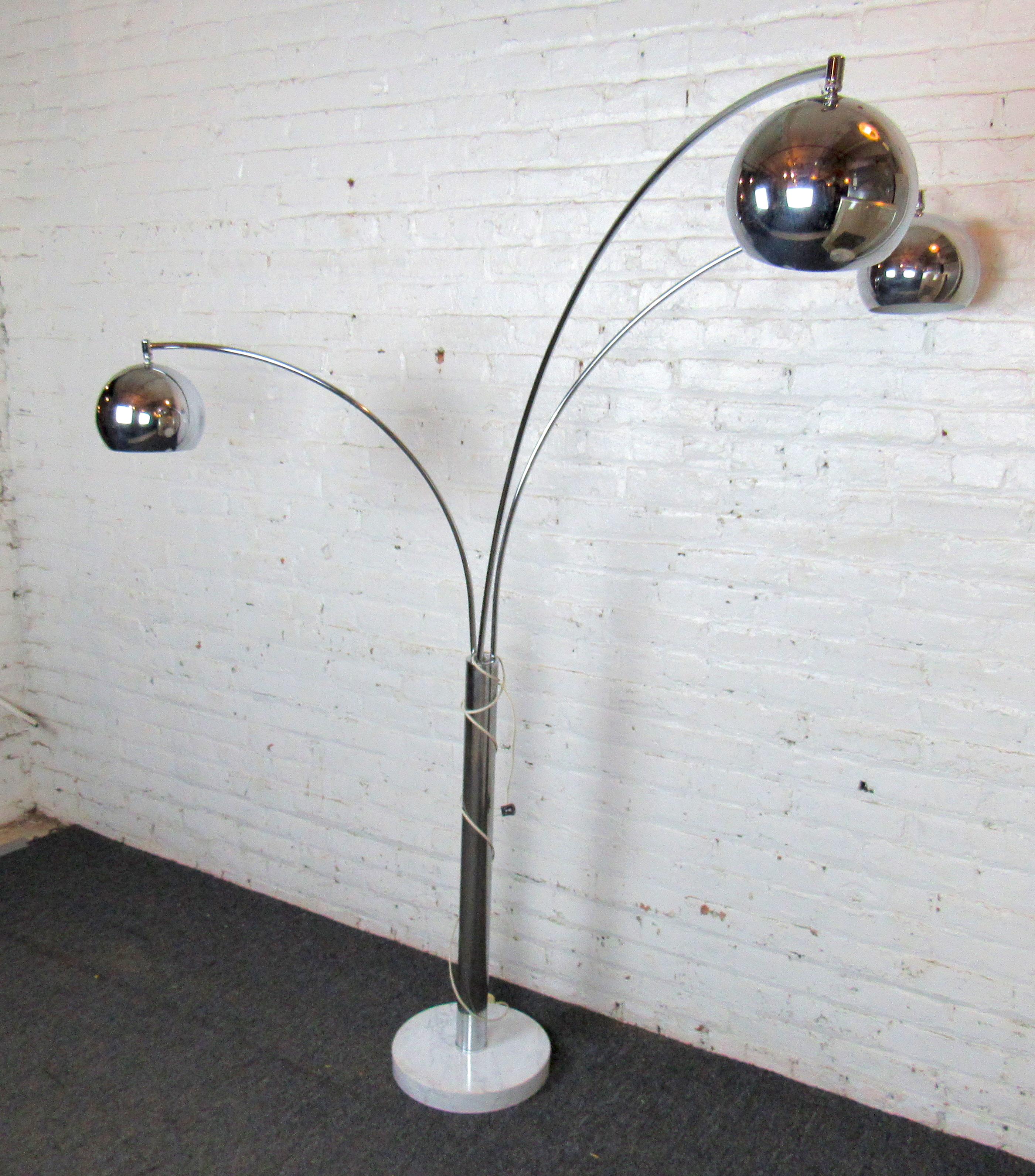 A Mid-Century Modern floor, arch lamp with three movable lamp heads. This lamp sits on a white marble base, all heads have beautiful globes that take medium base lightbulbs. Perfect addition to a den or office for versatile lighting. 
(Please