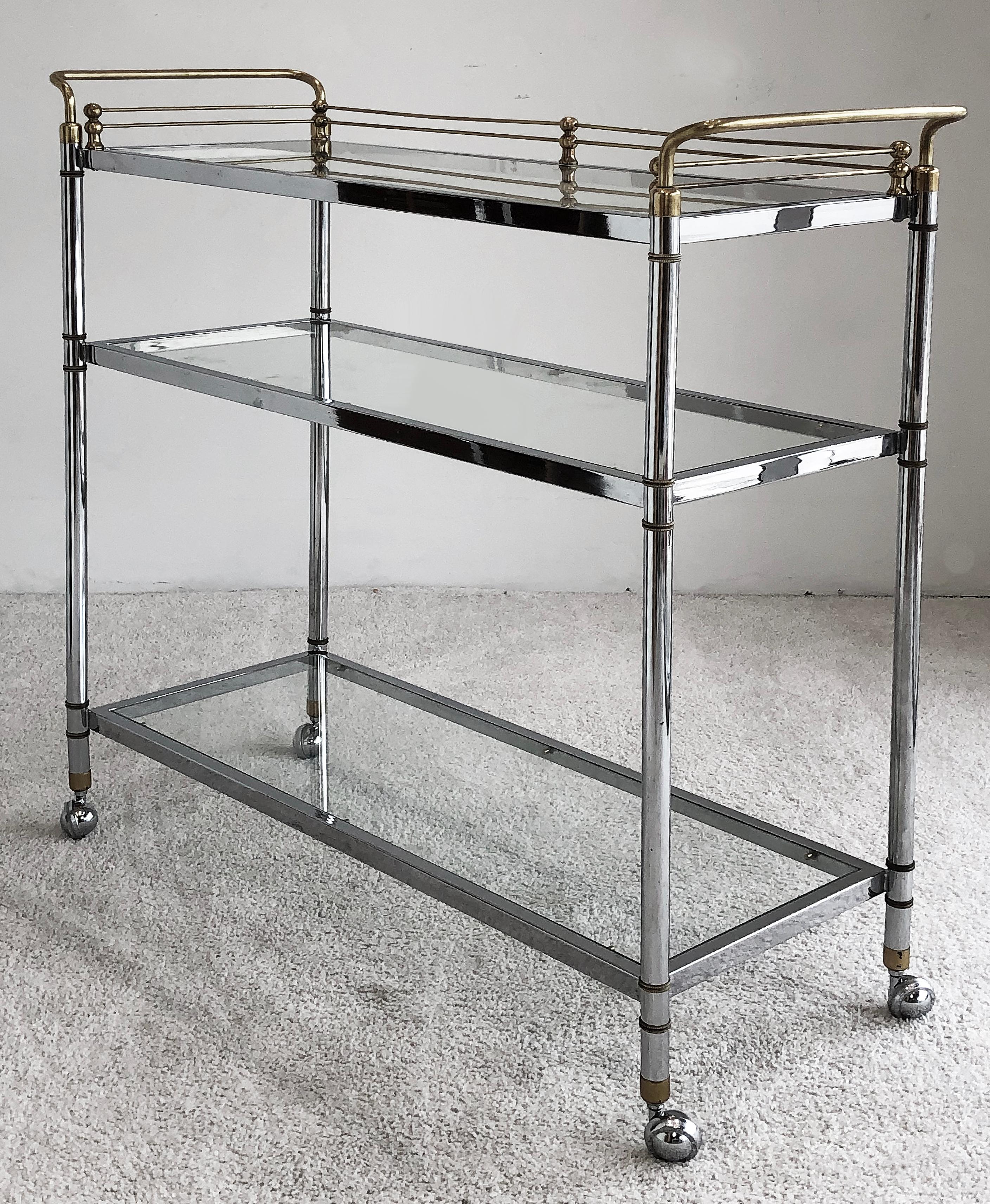 Midcentury chrome/brass Maison Jansen style bar cart 

Offered for sale is an elegant 1970s rolling Maison Jansen style bar cart in chrome and brass. The cart has 3 glass shelves providing ample storage. Because the cart has been designed with the
