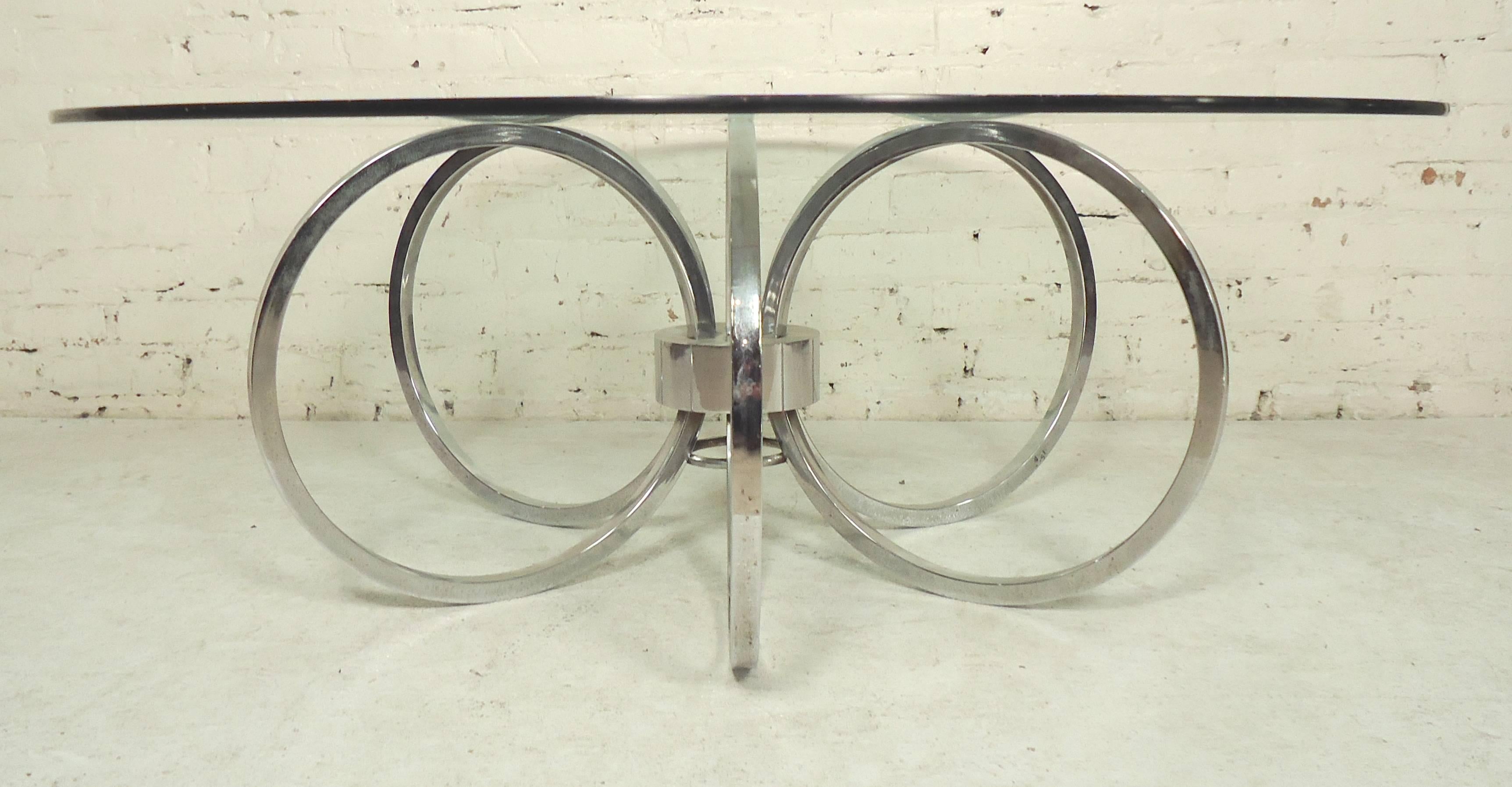 Round glass top coffee table with polished base made of chrome rings.

(Please confirm item location - NY or NJ - with dealer).
 