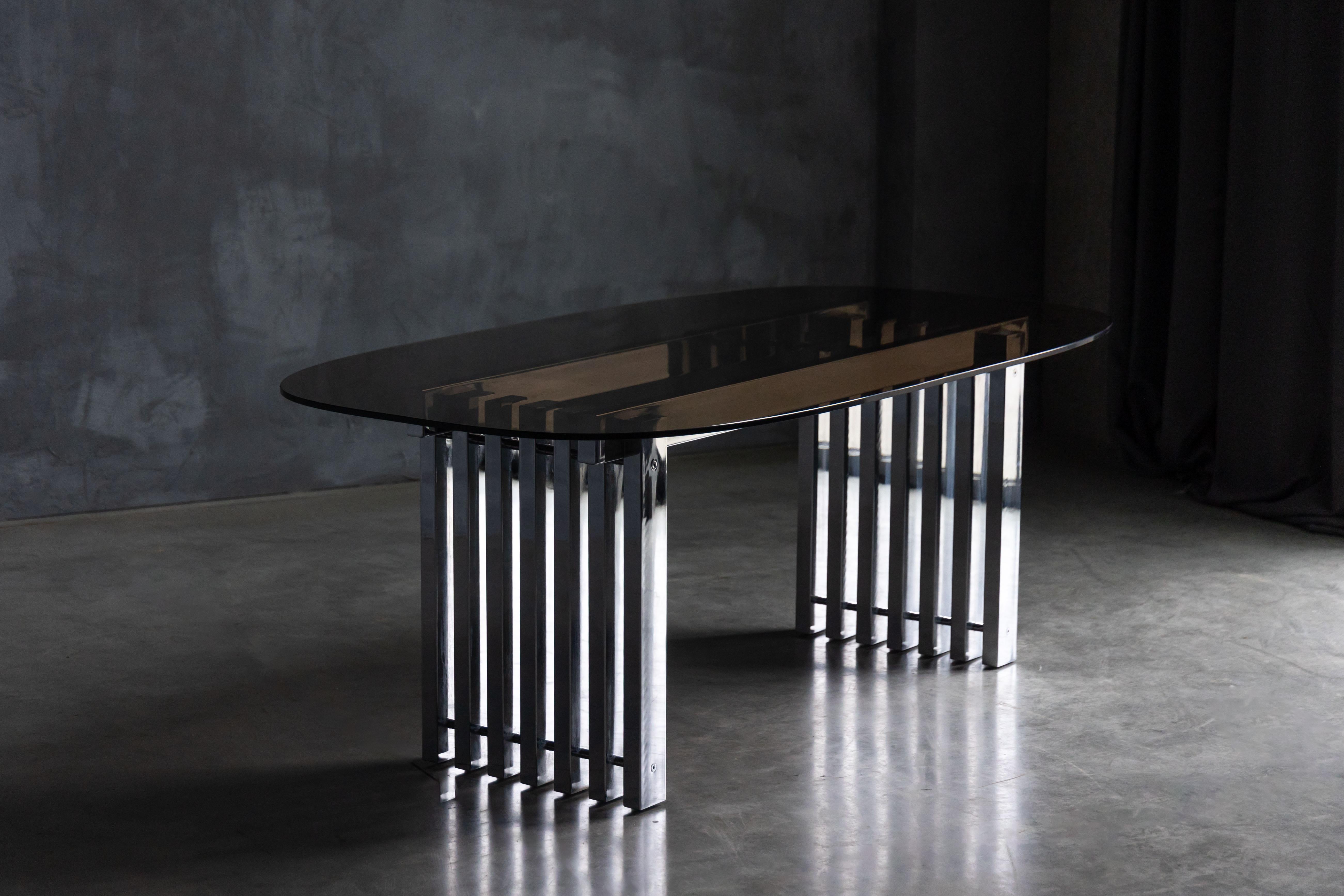 Cette étonnante table de salle à manger Roche Bobois, fabriquée vers les années 1970, présente un contraste saisissant entre un chrome élégant et un plateau en verre fumé sophistiqué. Le design unique met en valeur un ensemble de piliers verticaux