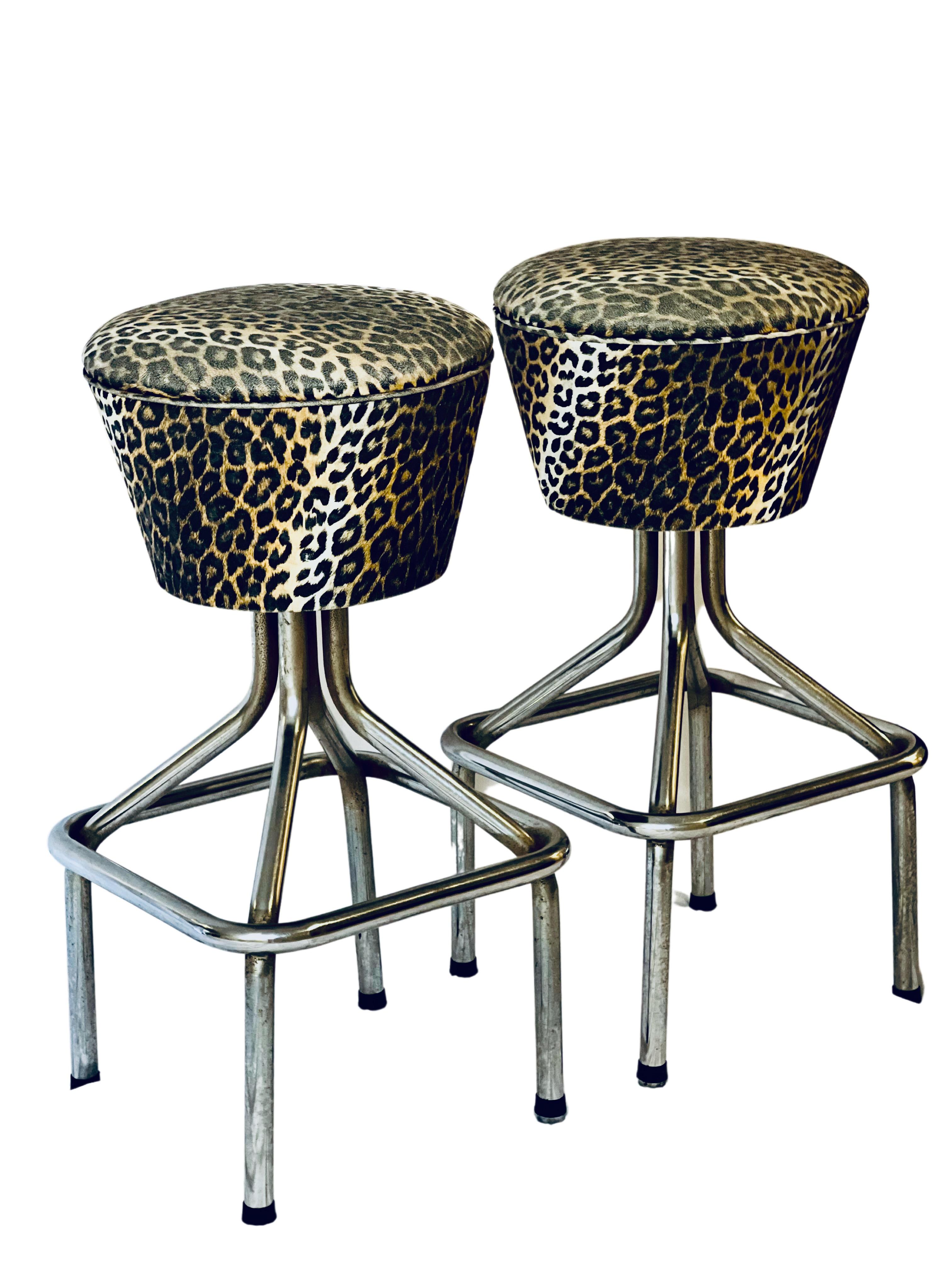 Fabulous pair of vintage swivel bar stools in faux leopard. 

The stools feature original fabric with a great print in good condition, no tears or stains. Unique design with an elongated and chunky tapered seat which swivels 360 degrees smoothly.