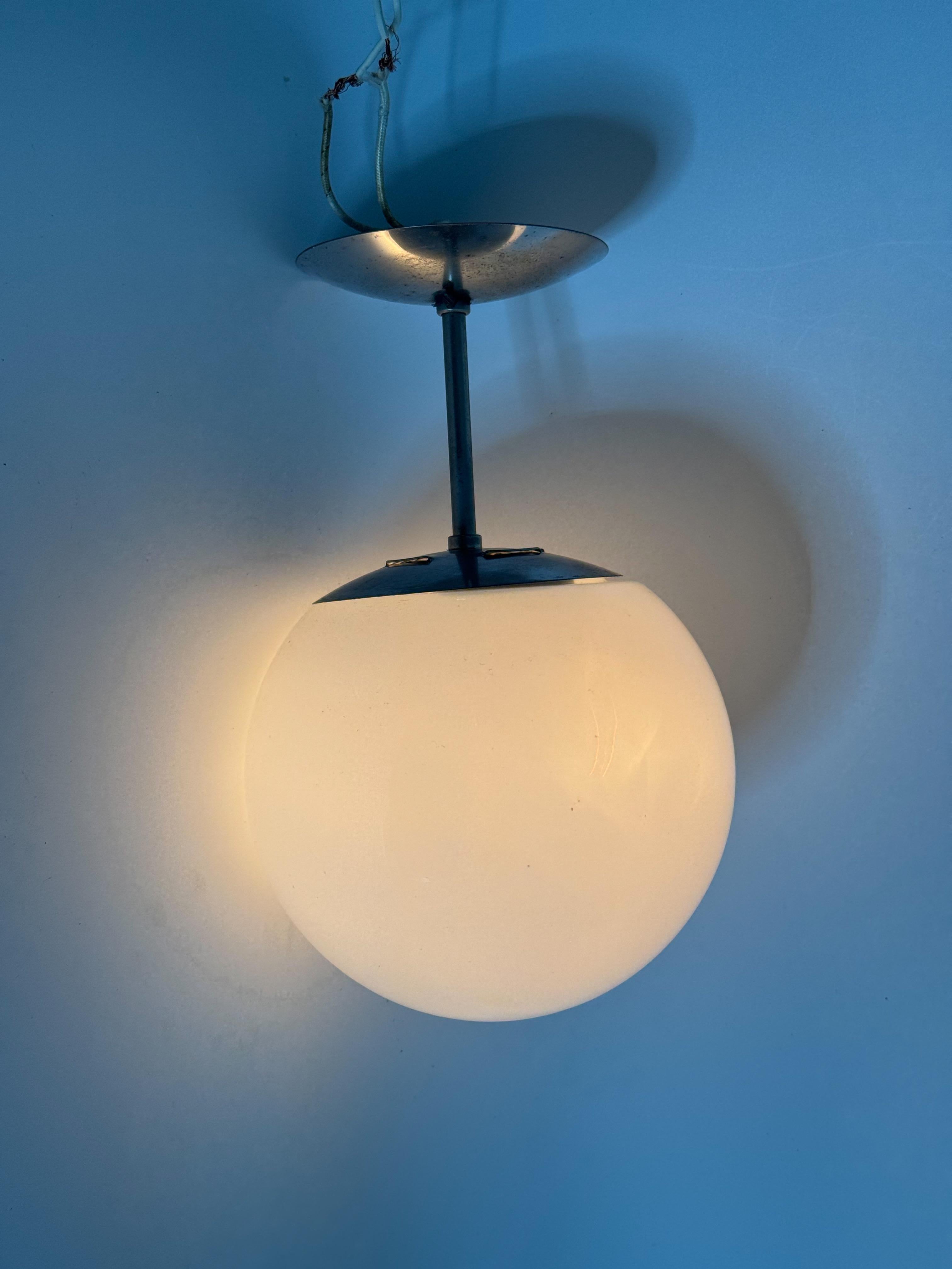 This vintage flush-mount ceiling light epitomizes mid‑century modern design with its sleek chrome hardware and classic opaline glass globe. Crafted circa 1960s–70s, the fixture features a clean-lined stem and canopy supporting a luminous orb—a style
