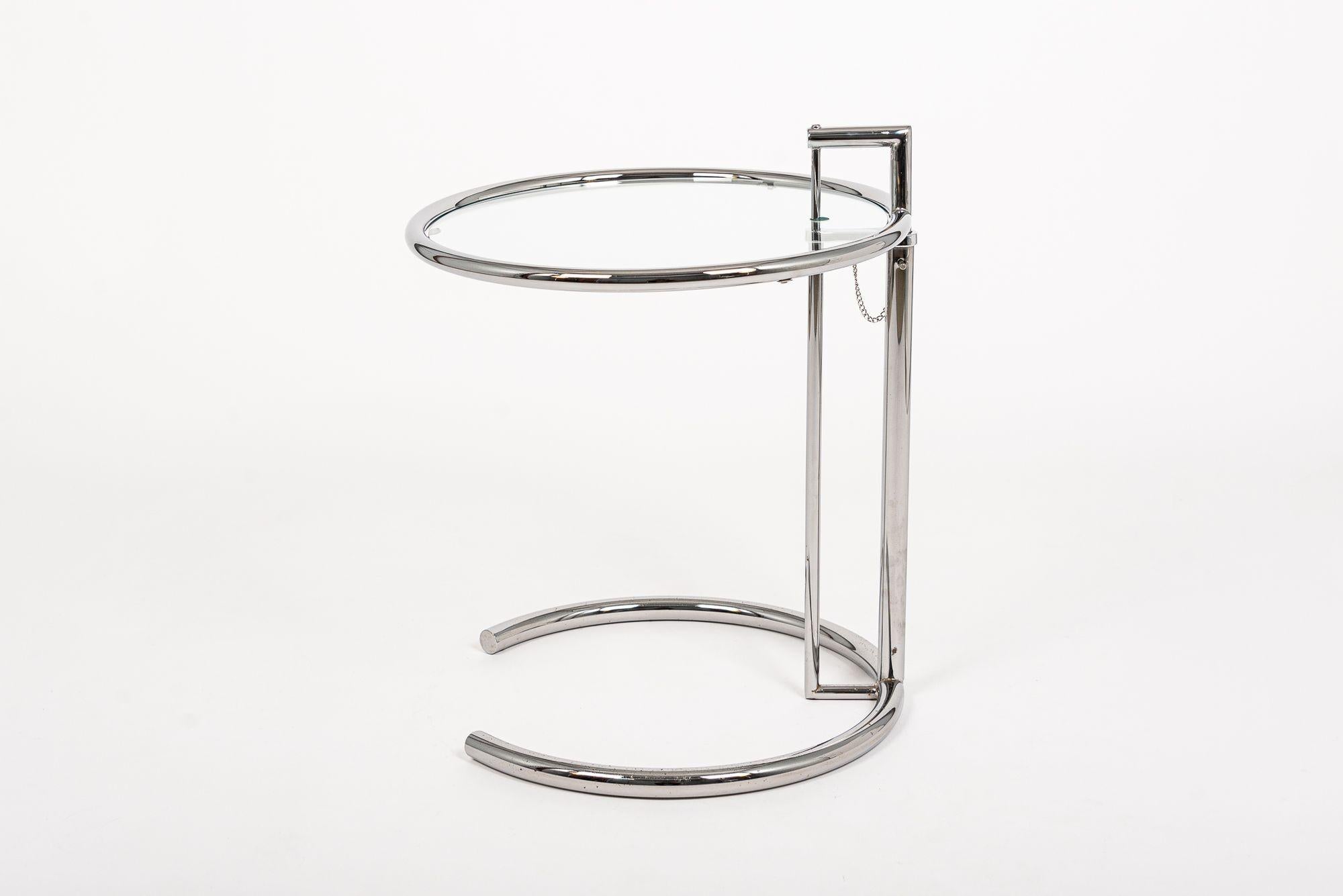 This tubular steel and glass Eileen Gray (attributed) E1027 end table was originally designed by Gray in 1926. The ingenious design features a chrome-plated tubular steel frame with circular glass tabletop that cantilevers over a c-shaped base. The
