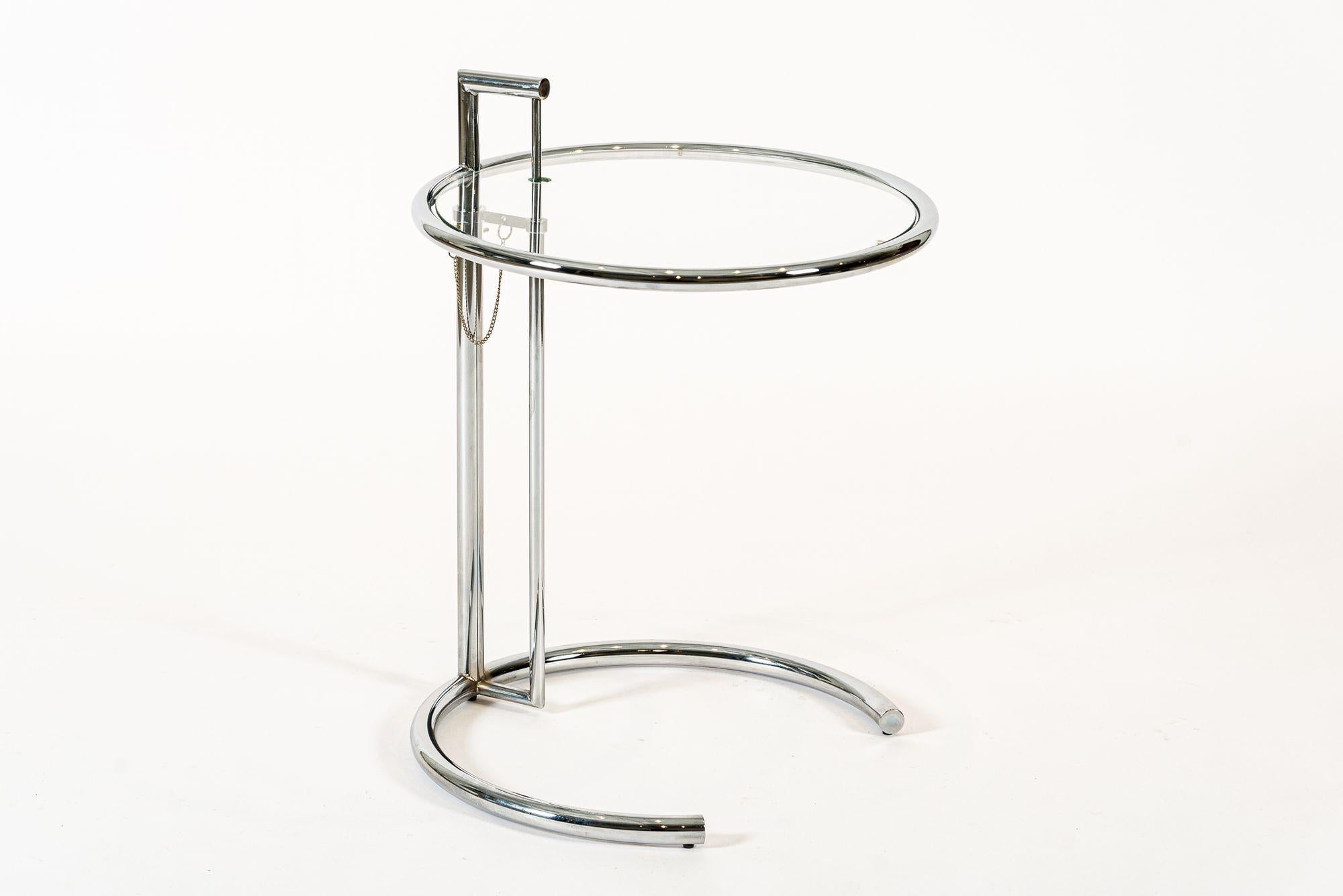 This Bauhaus tubular steel and glass Eileen Gray (attributed) E1027 end table was originally designed by Gray in 1926. The ingenious design features a chrome-plated tubular steel frame with circular glass tabletop that cantilevers over a c-shaped
