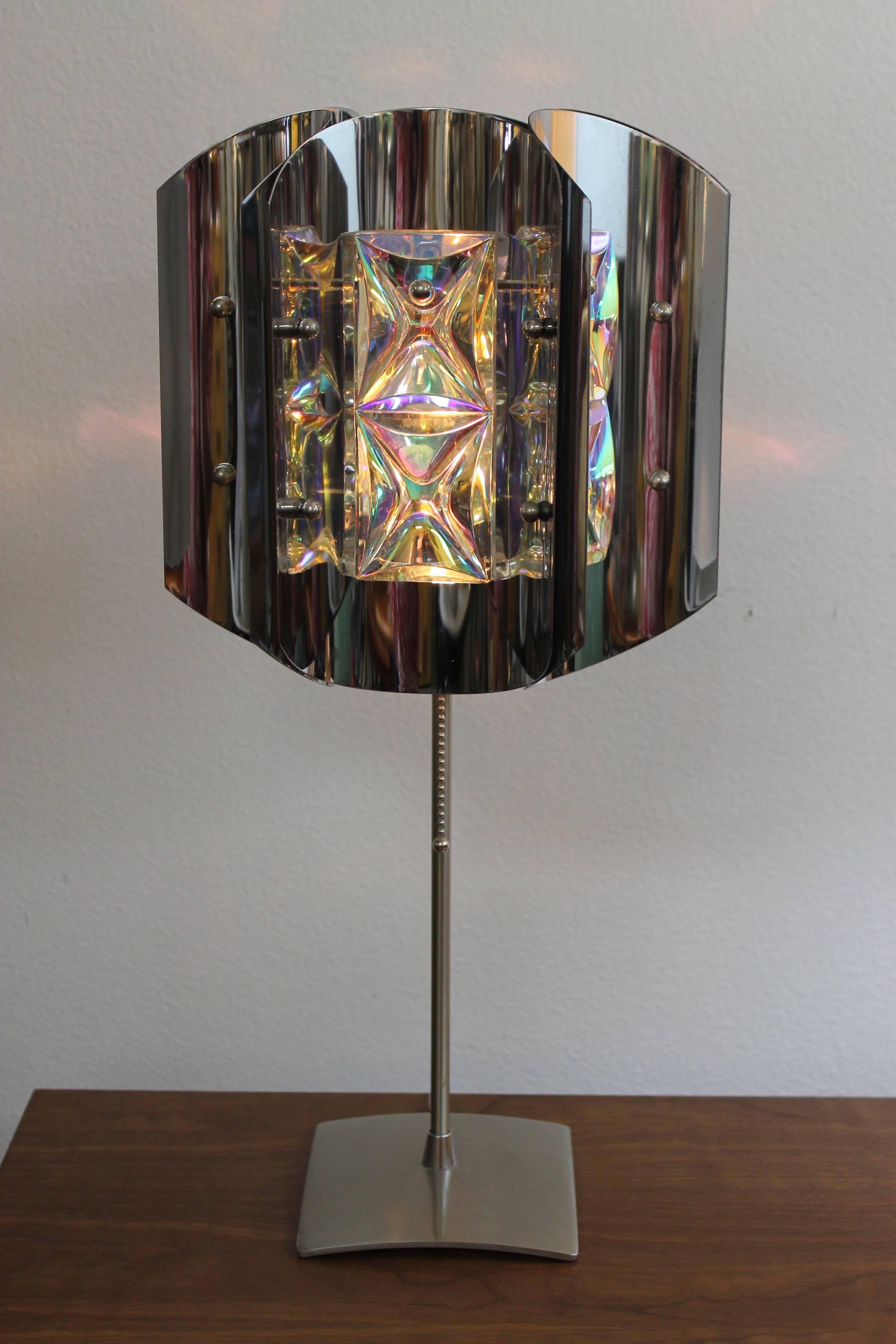 Originally a hanging pendant light, this chrome fixture has been re-purposed as a table lamp with a contemporary Italian base. The shade is circa 1970s, and features iridescent optical crystals that reflect a myriad of colors within the concave