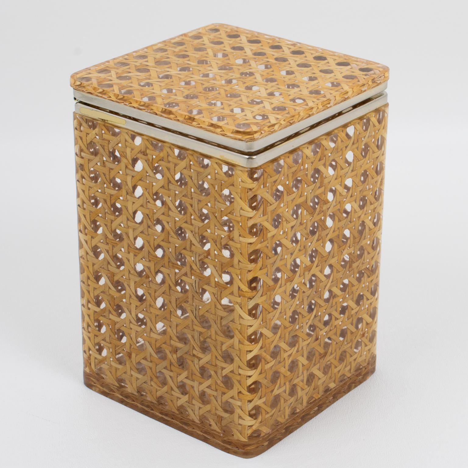This gorgeous decorative tall box is perfect for a living space or vanity. The chrome-plated framing is complemented with clear Lucite and rattan or wicker cane work. The rattan is embedded within two thick sheets of clear Lucite or acrylic material