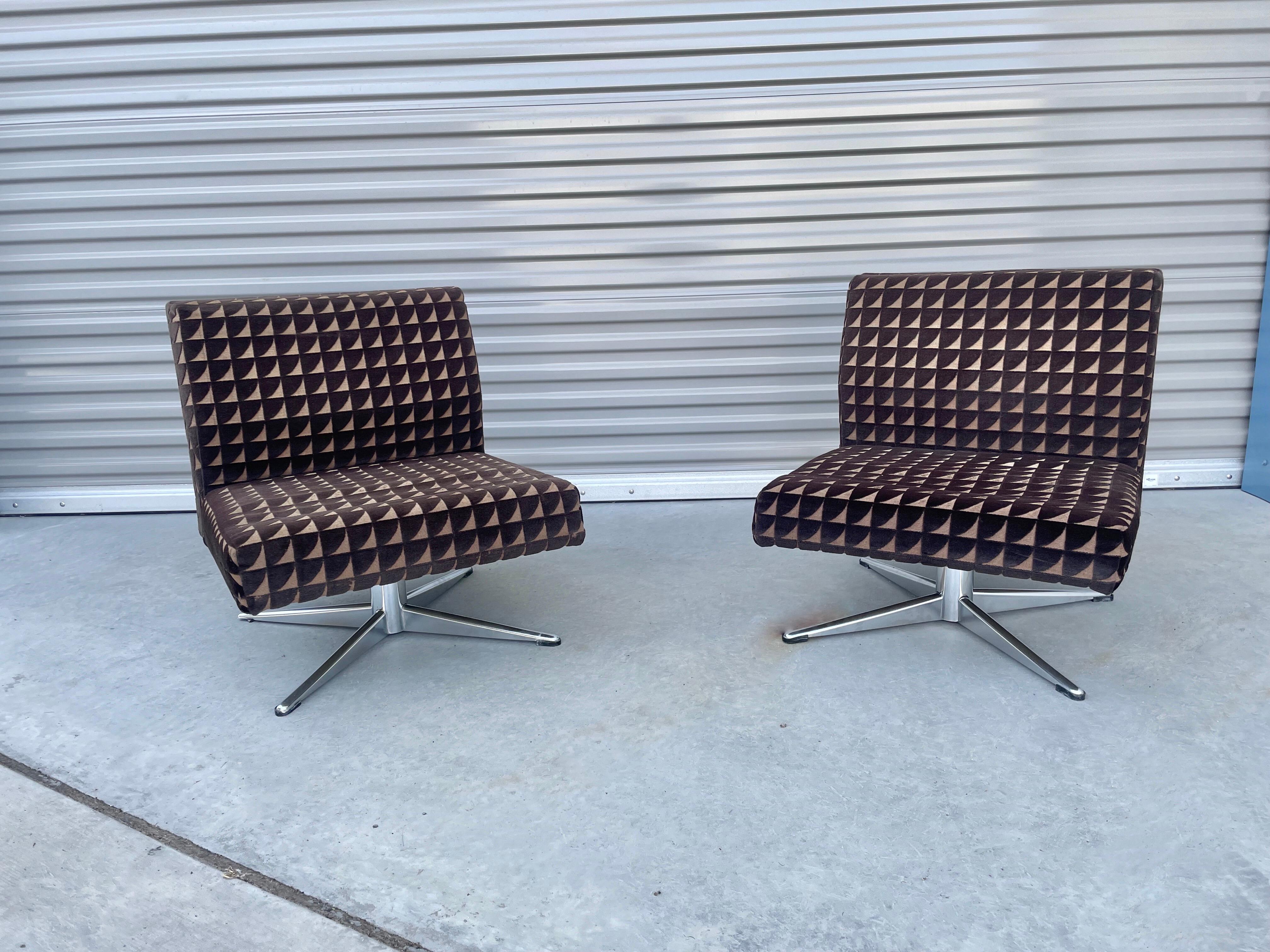 Midcentury pair of chrome swivel lounge chairs. These vintage lounge chairs features a unique curved backrest with a chrome swivel base giving the chair a unique design. The chairs can be used as lounge chairs or side chairs, making them