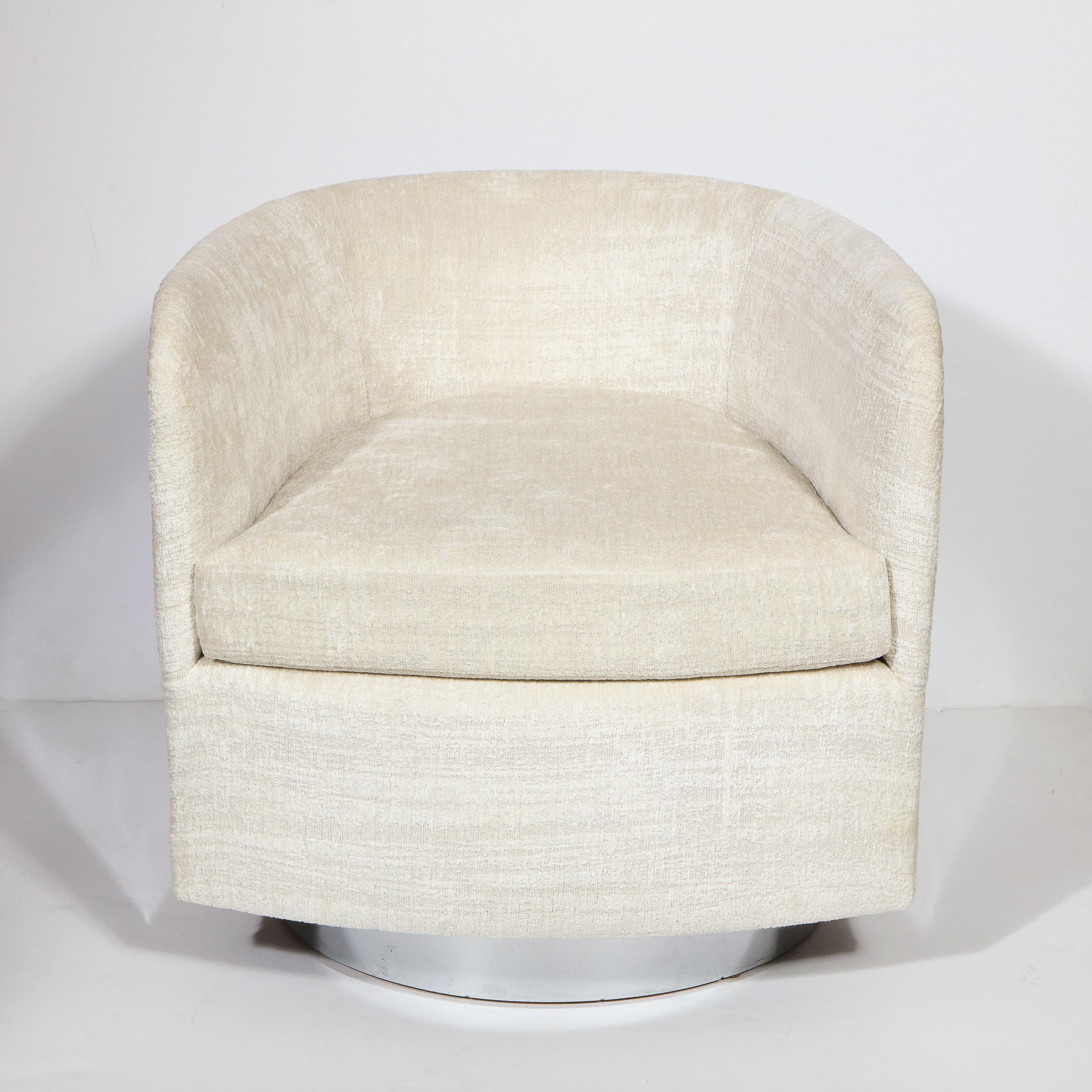 This stunning Mid-Century Modern chair was realized by the esteemed designer Milo Baughman, circa 1970. It features a barrel back wrapped in chrome with a luxurious cream bouclé fabric interior, sitting on a circular chrome swivel base. With its