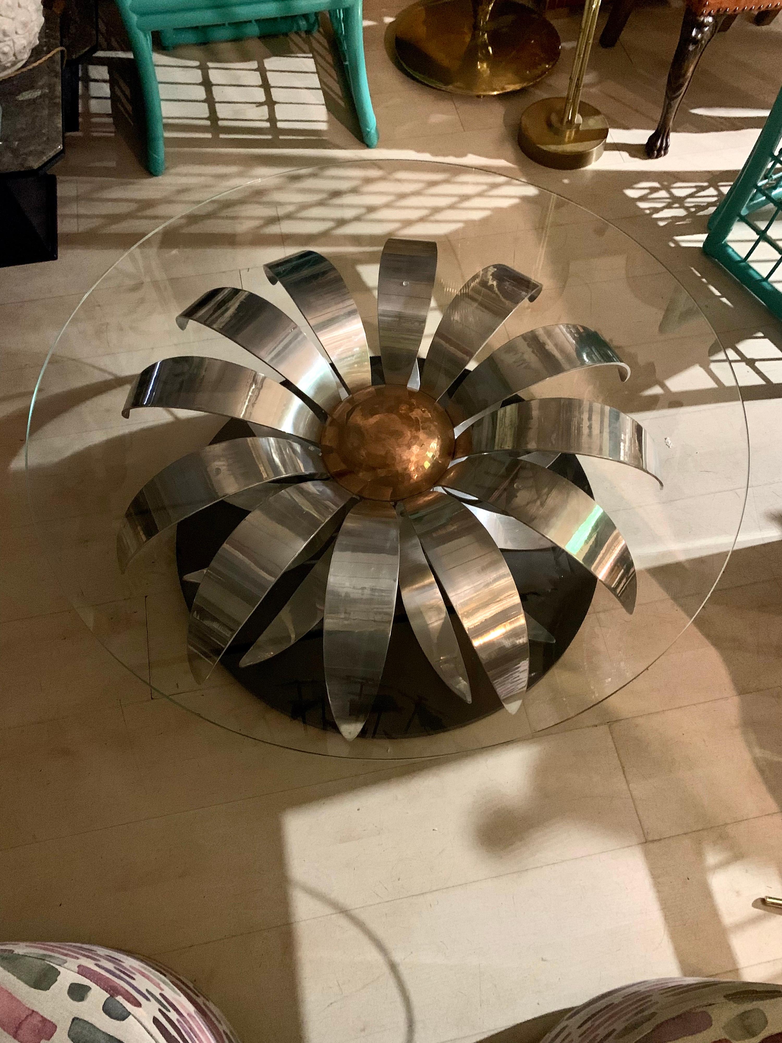 Mid-century chromed metal flower round coffee table with crystal top and black wood base. 
The pistil of the flower is in hammered copper.
The crystal top shows normal signs of age and use,  perfect vintage condition.