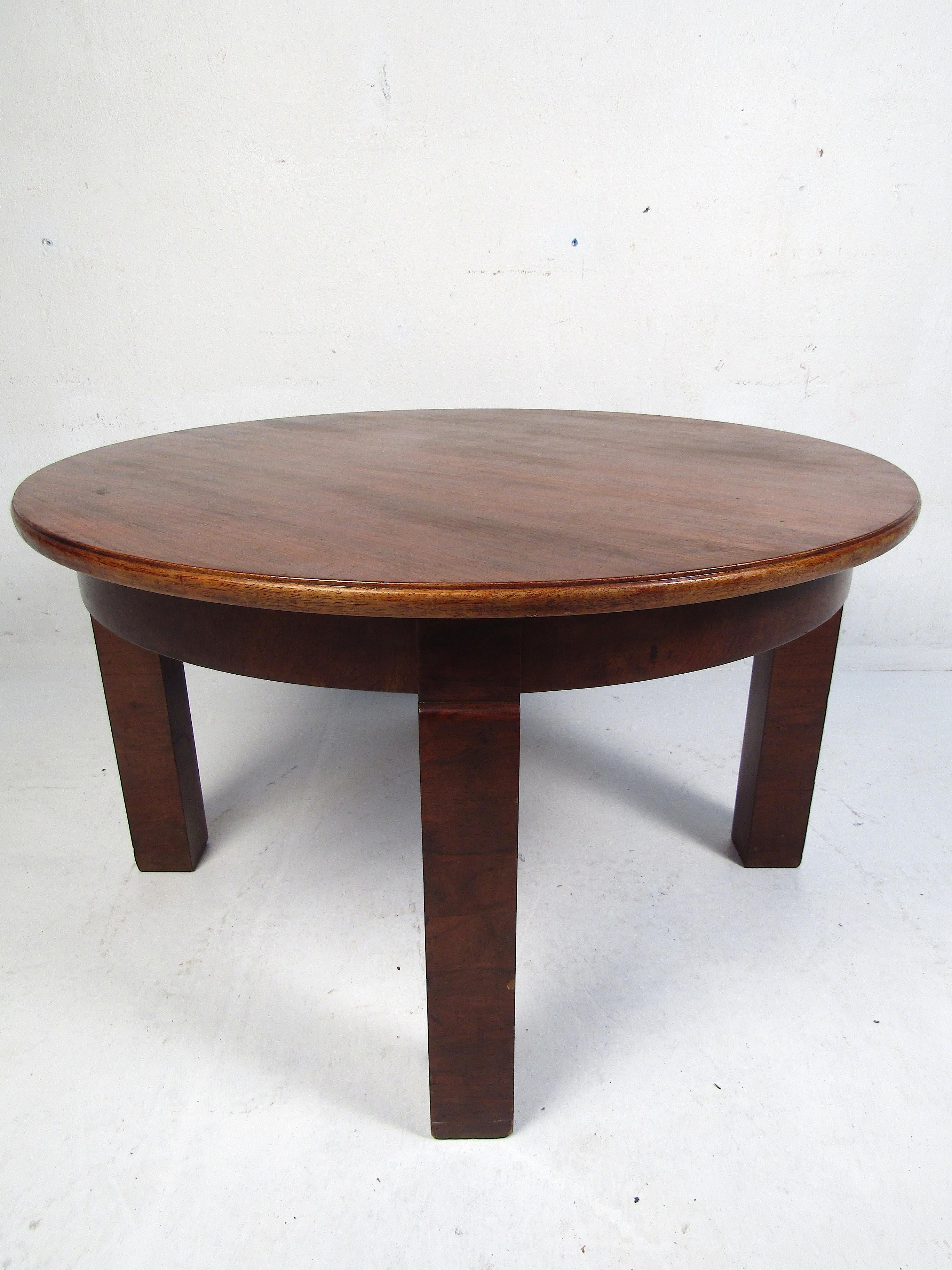 Interesting mid-century coffee table. Attractive wood grain pattern on the circular tabletop. Marked underneath - 