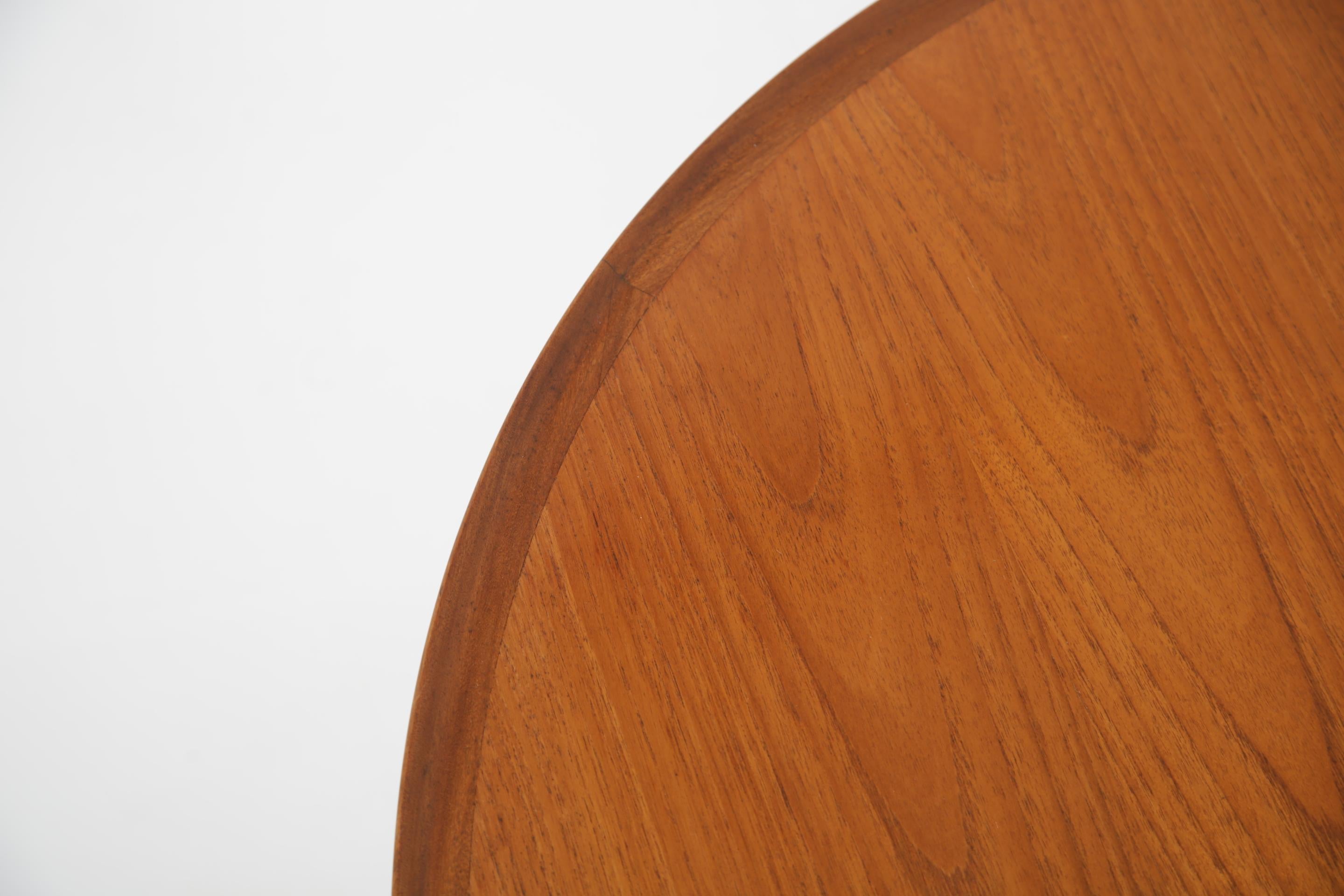 Take a look at this gorgeous Danish teak coffee table, featuring a circular top with a sturdy four legged base with beautifully curved rails. The table is of minimalist design with a low raised edge around the trim of the coffee table. The table has