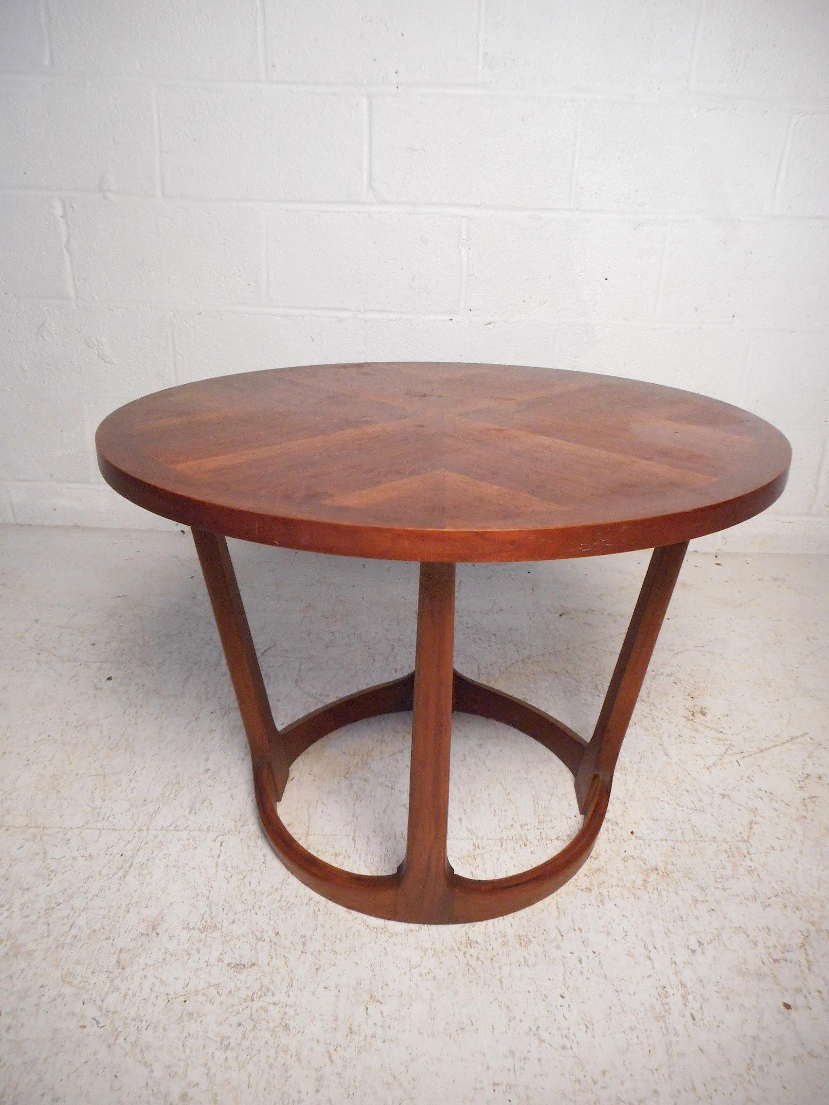 This stylish midcentury side table features a sturdy walnut construction, tapered supports, and a circular tabletop showcasing an interesting grain pattern. Made by Lane in 1964, this table is sure to make a great addition to any modern interior.