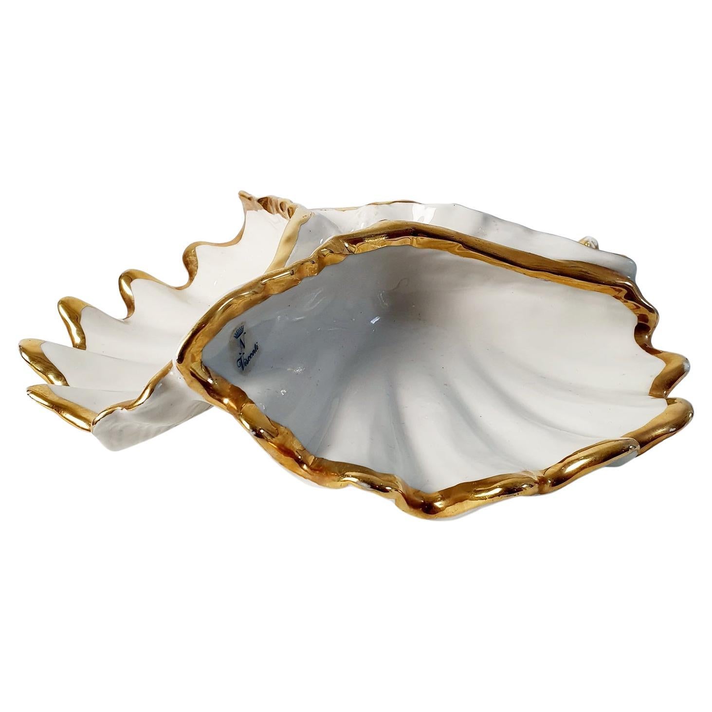 Una ciotola a conchiglia di Capodimonte in porcellana bianca avorio divisa in tre sezioni con bordi dorati. Marcato con l'adesivo Visconti e la N coronata. Perfetto per diversi snack o gioielli.
L'oro è un po' consumato, ma non è scheggiato.