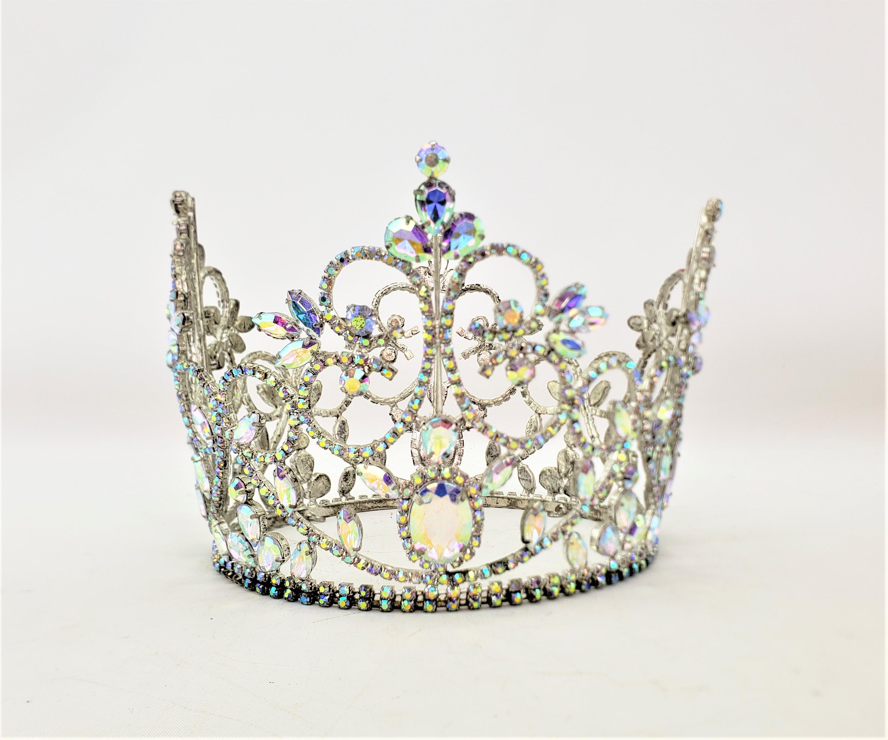 This vintage crown is unsigned, but presumed to have originated from the United States and date to approximately 1955 and done in the period Mid-Century Modern style. The frame of the crown is done in a silver paste with hundreds of small and cut