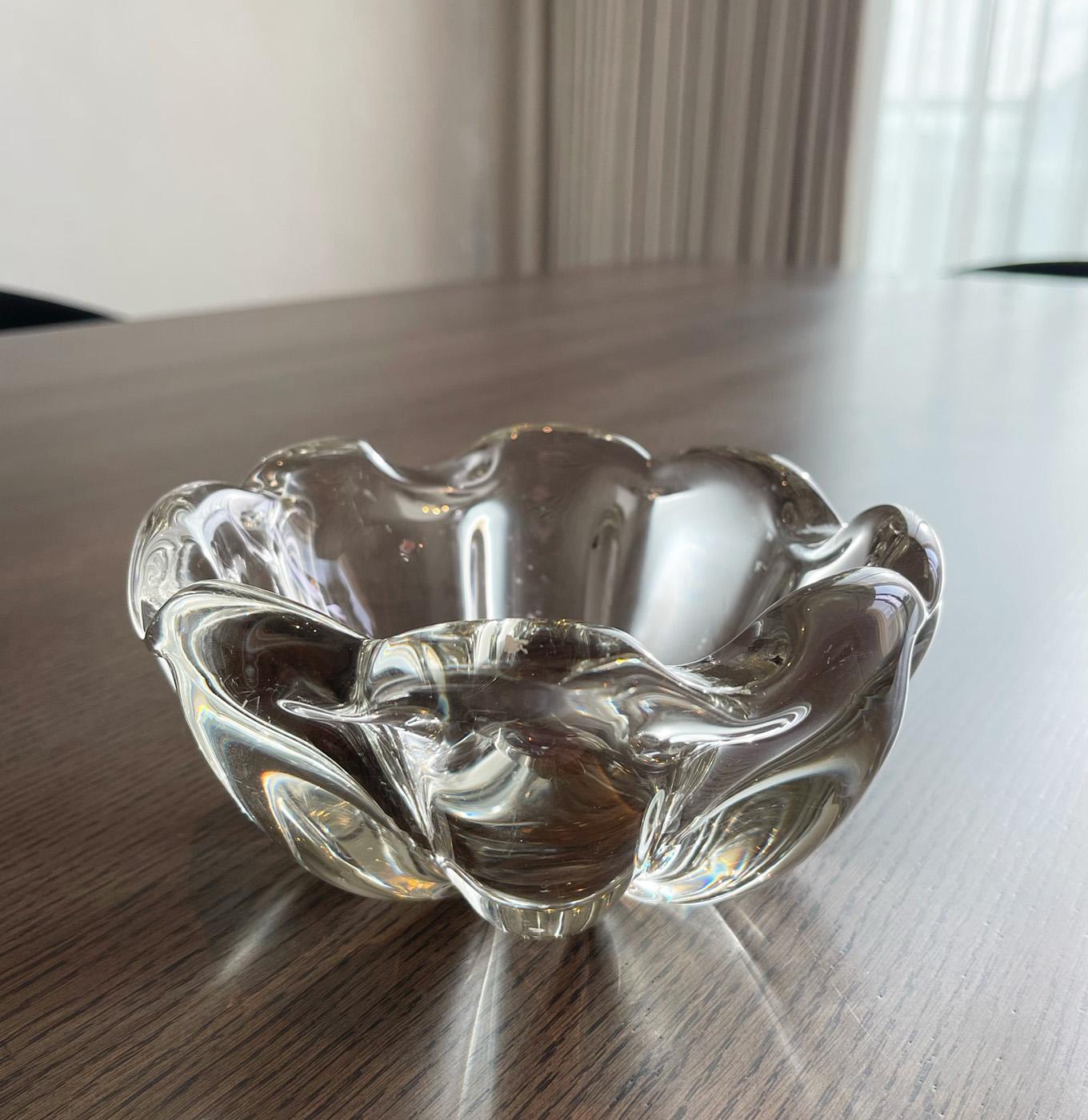Clear crystal vide-poche.

Clear crystal vide-poche dish, attributed to Daum Crystal. 

Beautiful organic forms make up this dish; stylistically very 1960's. This dish is a fine example of an expert crystal maker. The base of this heavyweight