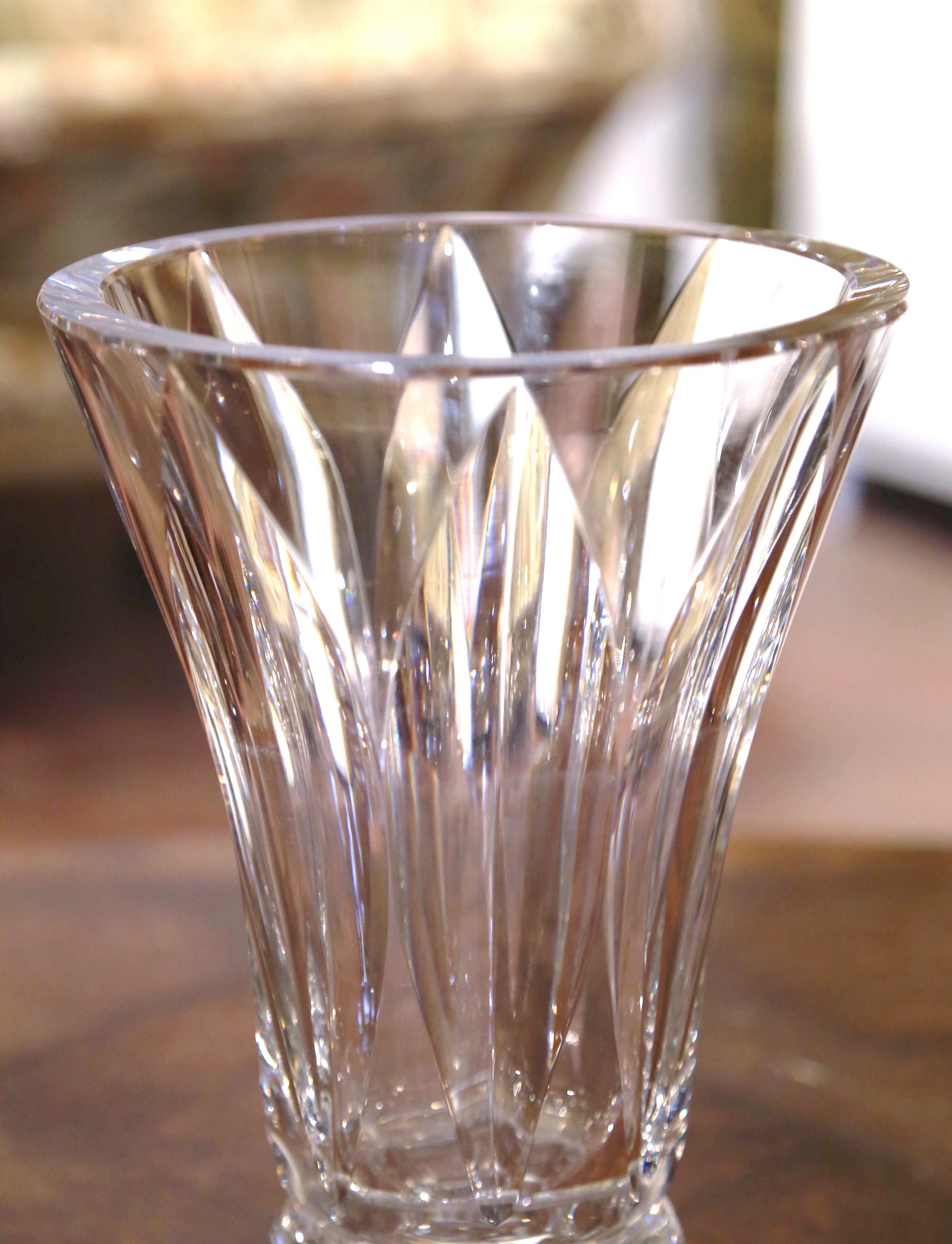 Decorate a console or buffet with this elegant crystal trumpet vase. Crafted in France, circa 1960 and round in shape, the large luxurious cut glass vessel is decorated throughout with geometric and leaf motifs; the tall and thick vessel flower vase