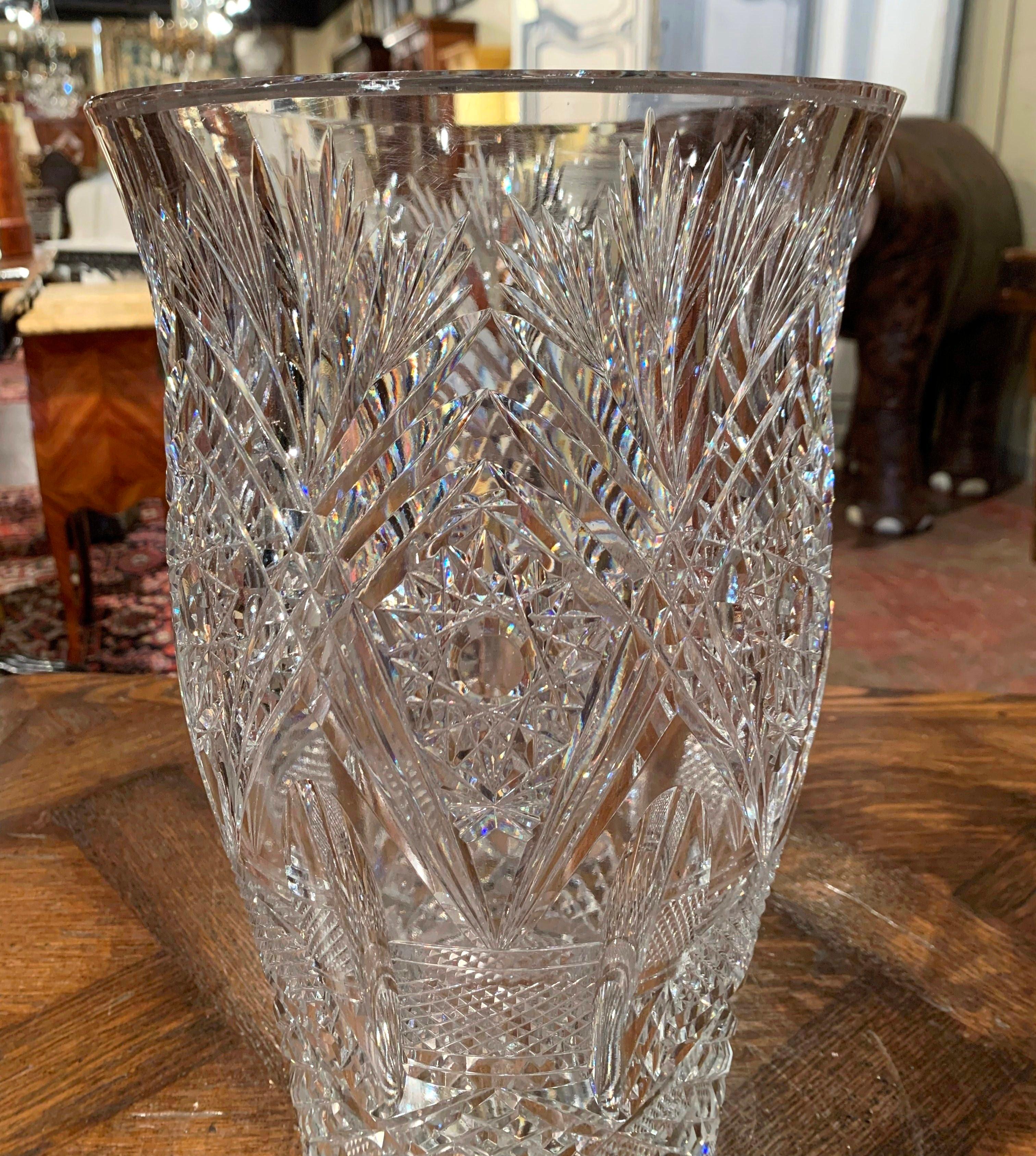 Decorate a dining table or buffet with this elegant crystal vase. Crafted in France, circa 1950, the large luxurious cut glass vessel is decorated throughout with floral, leaf and sun decor. The thick heavy vase is in excellent condition.
Measures: