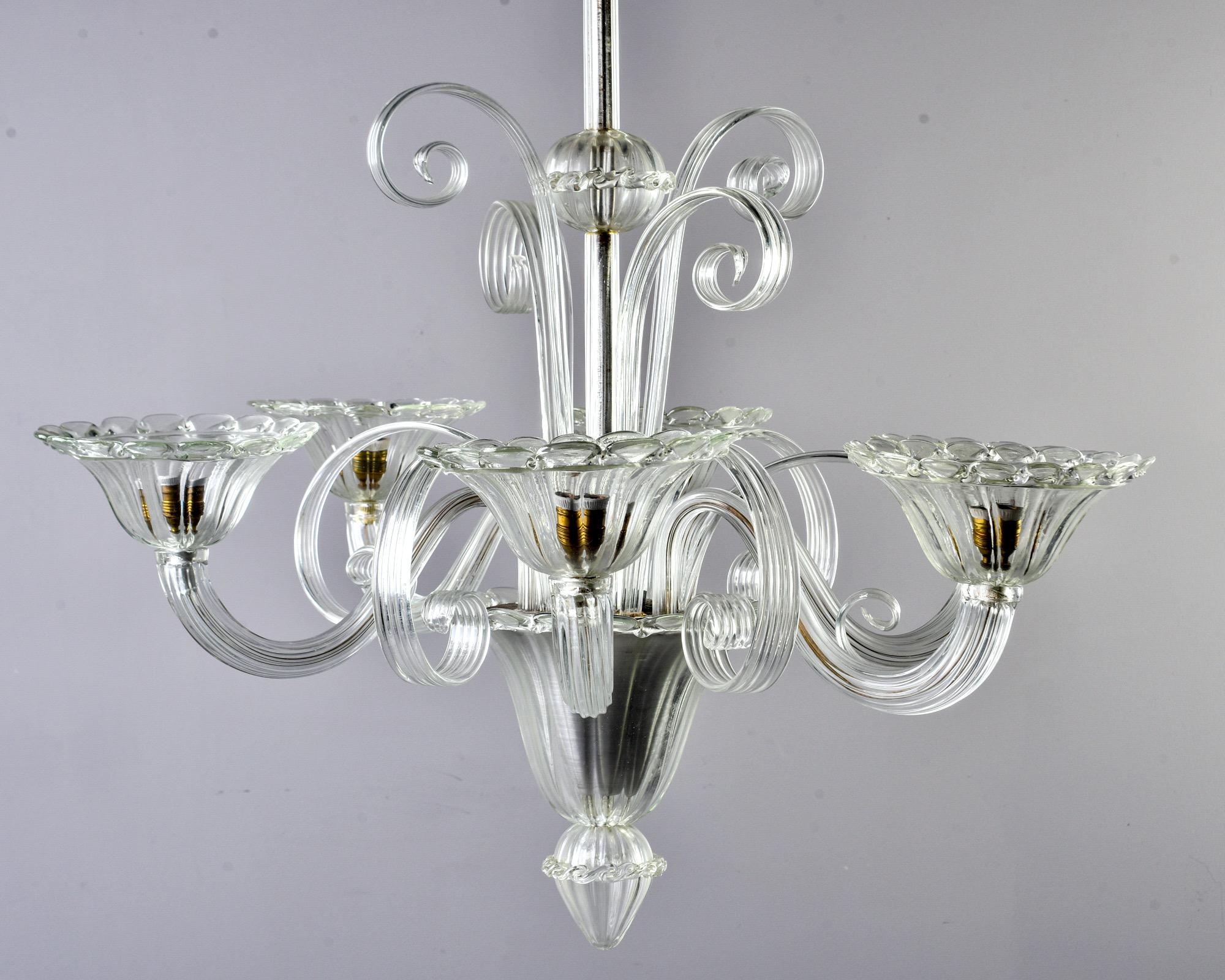 Murano chandelier in clear, mouth blown glass, circa 1960s. Original ceiling canopy, top tier of curled stems and six curved arms with petal-edged bobeches. New wiring for US electrical standards. Unknown maker.