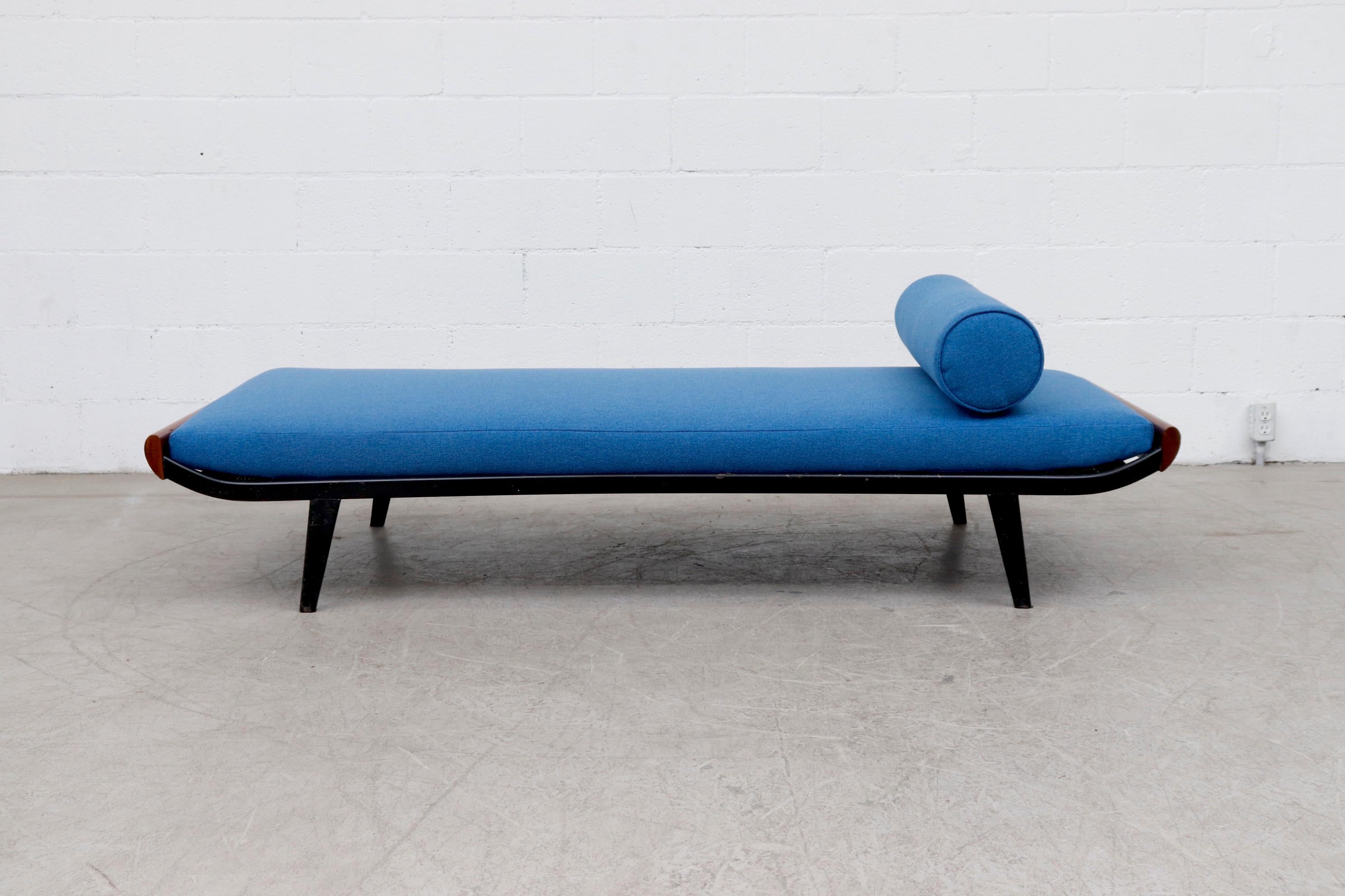 Beautiful 1960s Cleopatra daybed by A.R. Cordemeyer. Lightly refinished teak wood ends with dark grey metal enameled frame and 'Auping' tag on mesh springs with new azure blue mattress and matching bolster. Frame in original condition with visible