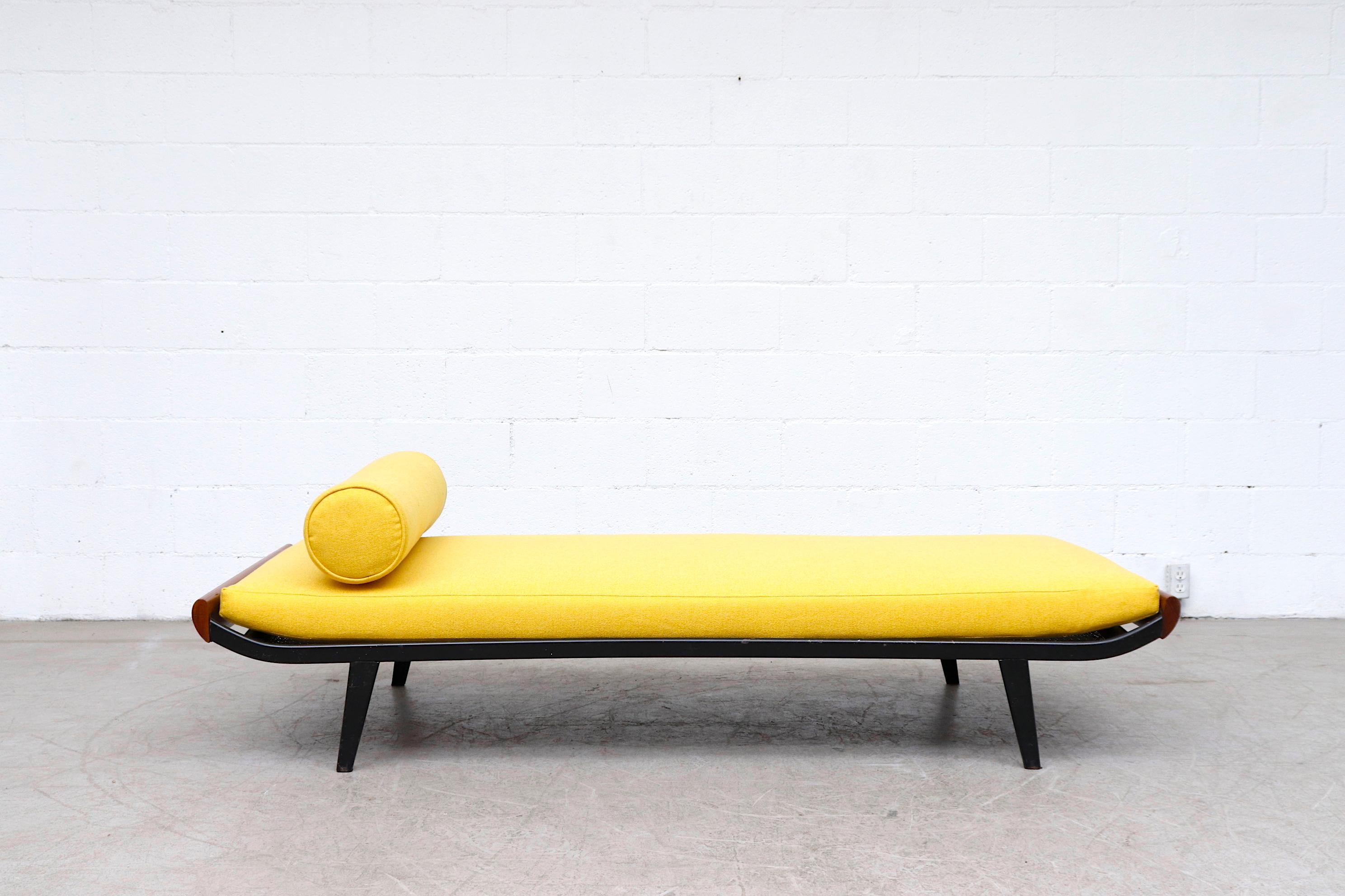 Beautiful 1960's Cleopatra style day bed by A.R. Cordemeyer. Lightly refinished teak wood ends with dark grey metal enameled frame and 'Auping' tag on mesh springs with new bright sunshine yellow mattress and matching bolster. Frame in original