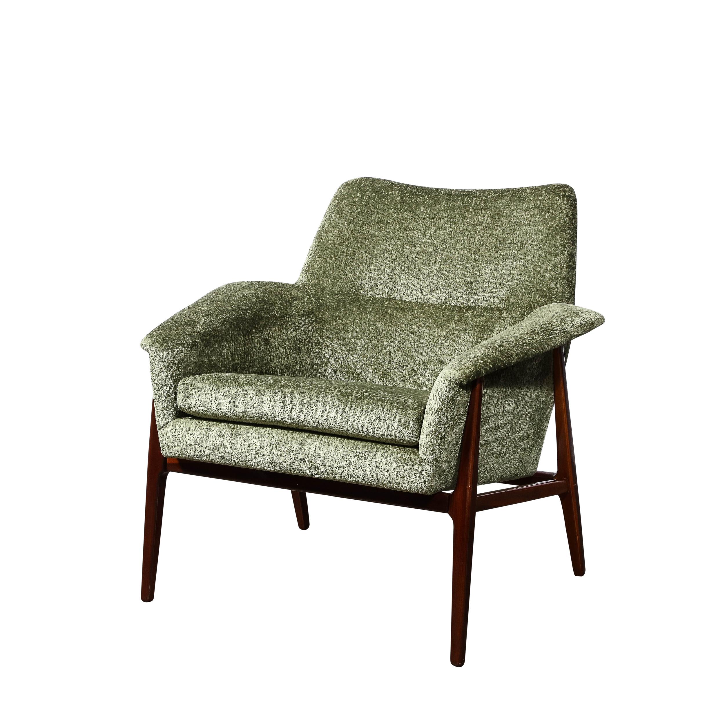 This stunning and graphic pair of Mid-Century Modern club/ lounge chairs were realized in the United States circa 1960. They feature straight tapered front legs and tapered hind legs angled at a bias connected at top and bottom by horizontal