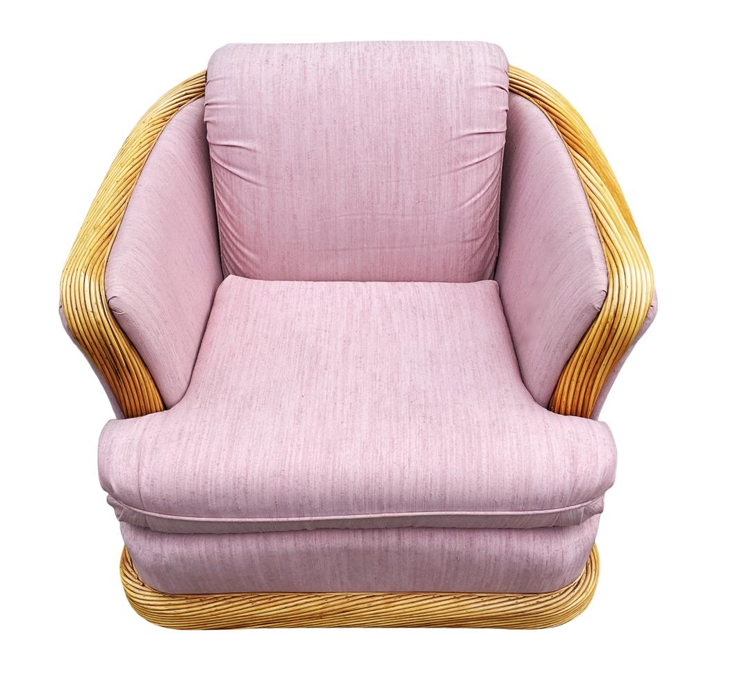 A super comfy club chair from the 1980's. It features woven rattan accent with the original pink fabric. Upholstery can use updating but very usable.