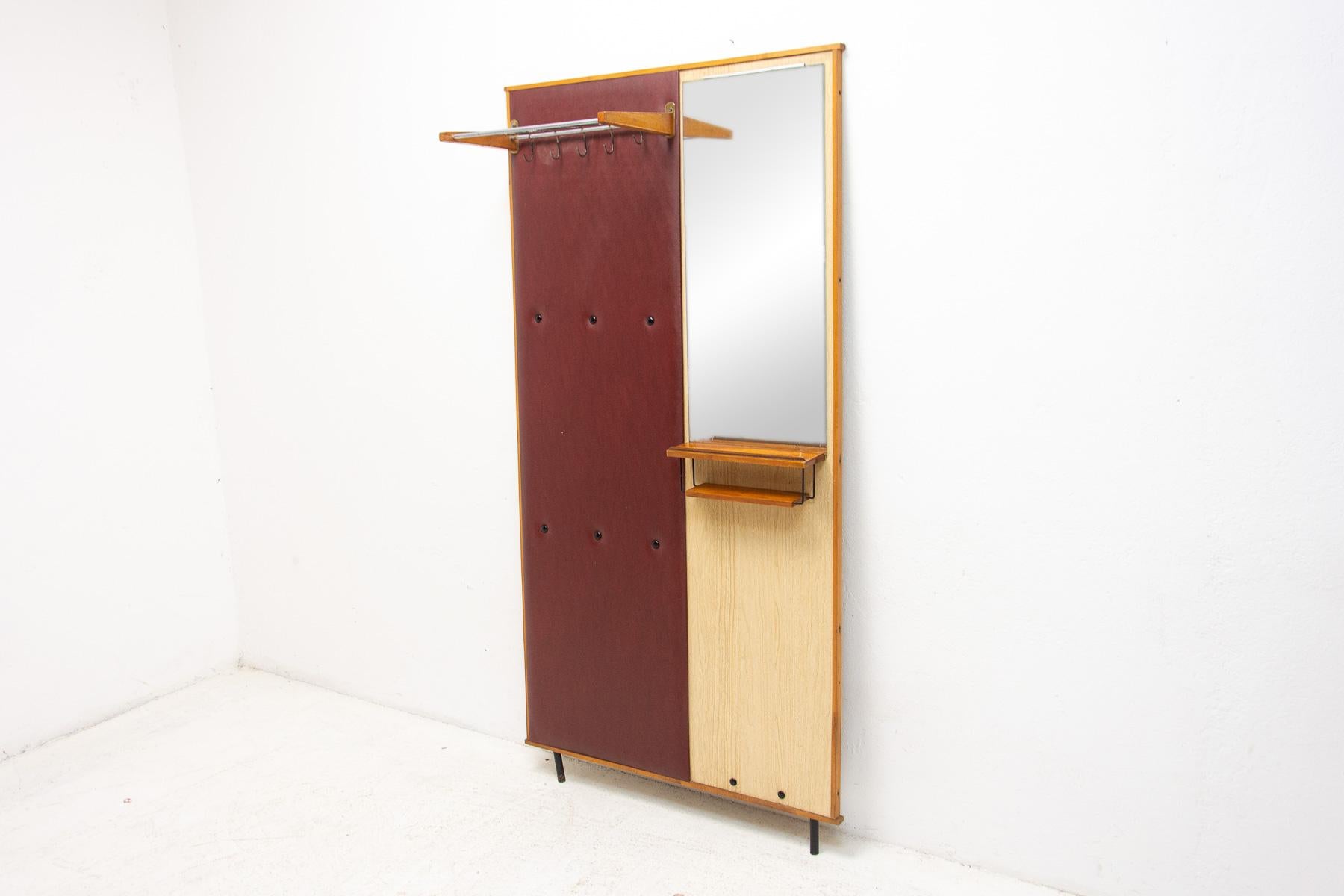 This hall coat rack was made in the former Czechoslovakia in the 1960s and produced by DREVOTVAR. Material: plywood, wood, leatherette, metal. It can be mounted on the wall or laid freely on the floor.

It is a characteristic example of