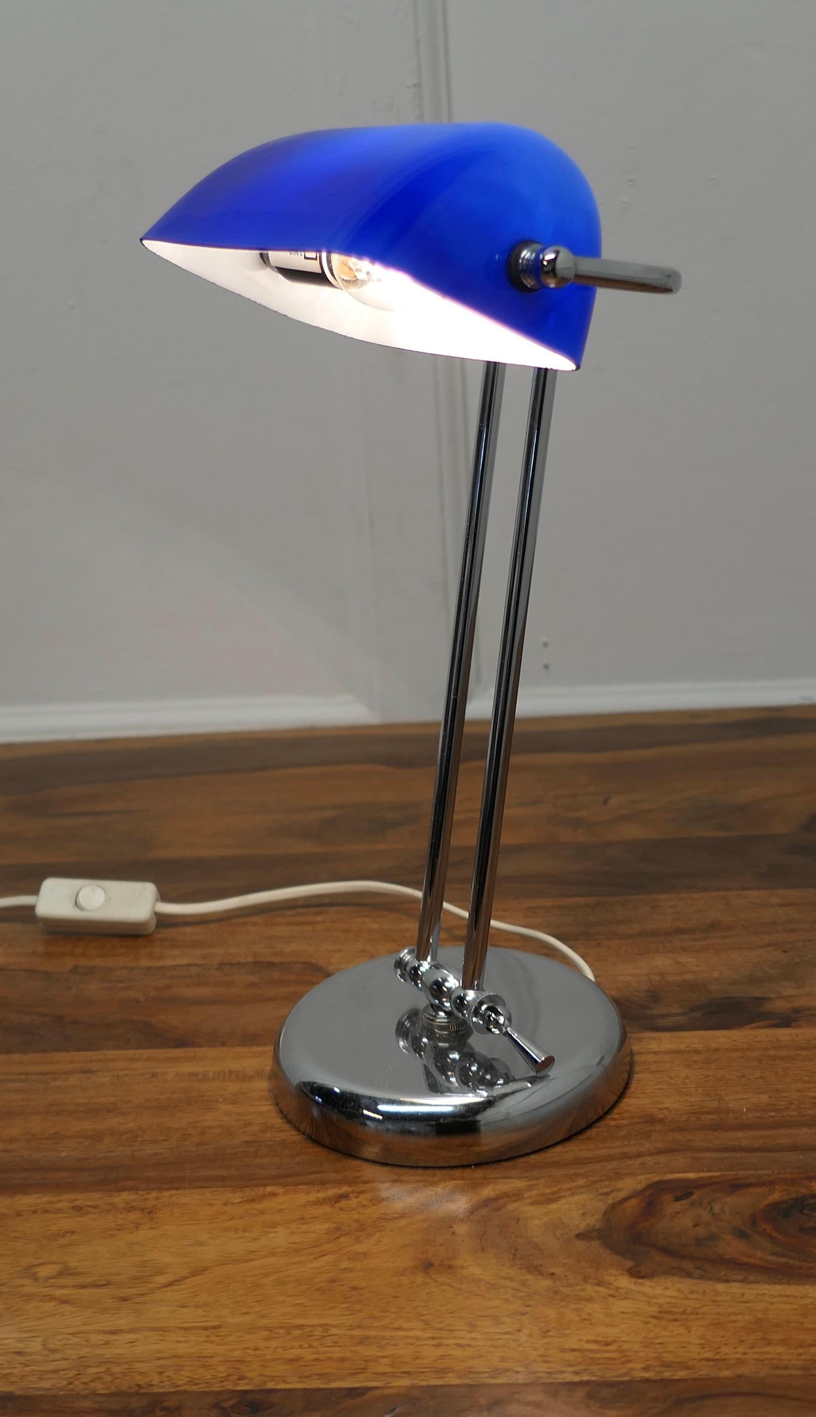 Mid Century Cobalt and Chrome Glass Library Desk Lamp

A beautiful quality fully adjustable Banker’s or Barrister’s desk lamp, with a Cobalt blue glass lampshade which has a white reflective underside set on a Chrome Frame
The Lamp is in good and