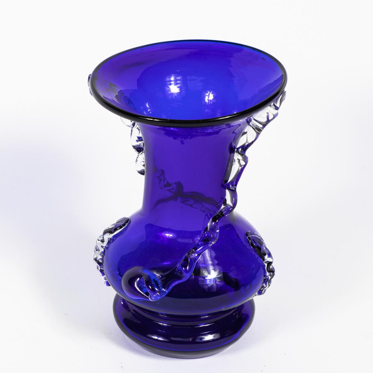 Mid-century cobalt blown glass vase with clear glass decoration. Glossy, tactile, and richly hued, the vase has gem-like appeal. Its gently fluted lip is in perfect proportional harmony with the rounded base. Delicate streams of clear glass buttress
