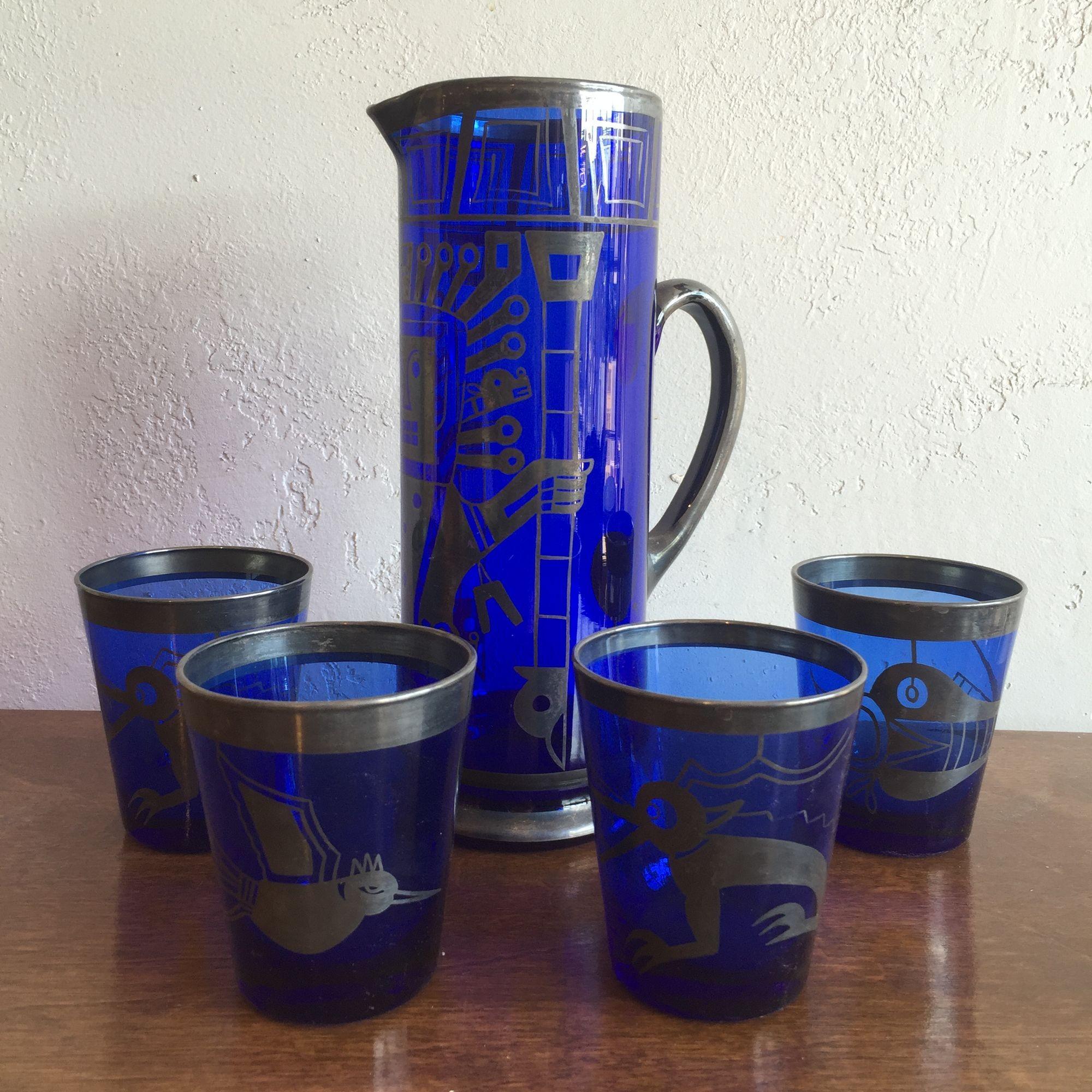 Unique ice tea, cocktail mixer set in cobalt blue glass with a silver Aztec design motif. The images appear to be hand painted in a sterling silver patina raku glaze.

Each glass has a different Mayan god or sprit creature.

In mint vintage