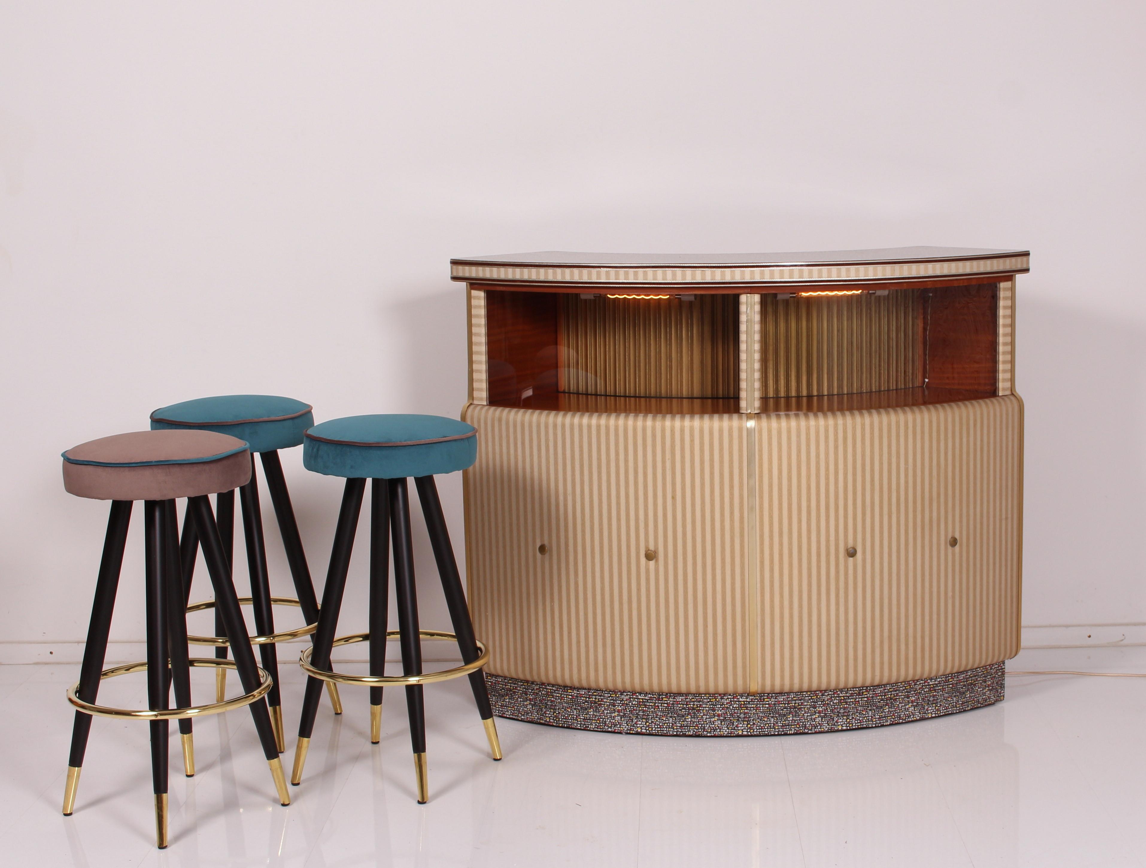 This spectacular English Cocktail Bar is in amazing good condition - fully revised and rewired. 
Its solid wooden body is veneered with Tola Wood. 
(botanic name: Gossweilerodendron Balsamiferum :: West and Central Afrika)
elegant curved teak