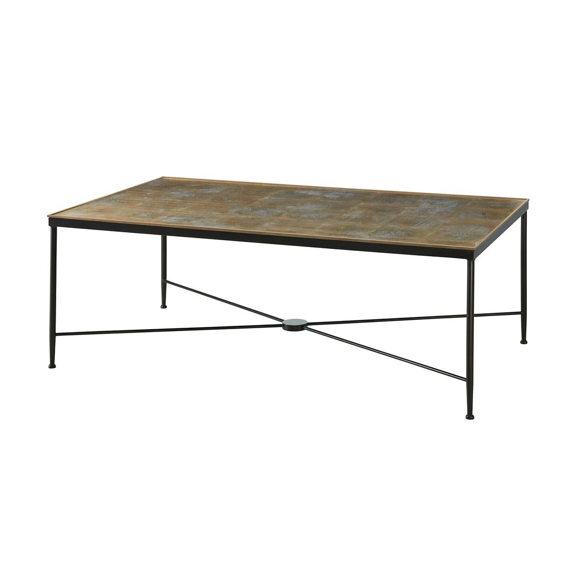 A midcentury Cocktail Table with Eglomisé Top with gold leaf etched details and a brass trim edge, above an ebonized wrought iron base with a X stretcher.

Dimensions: 50 W x 30 D x 18 H.