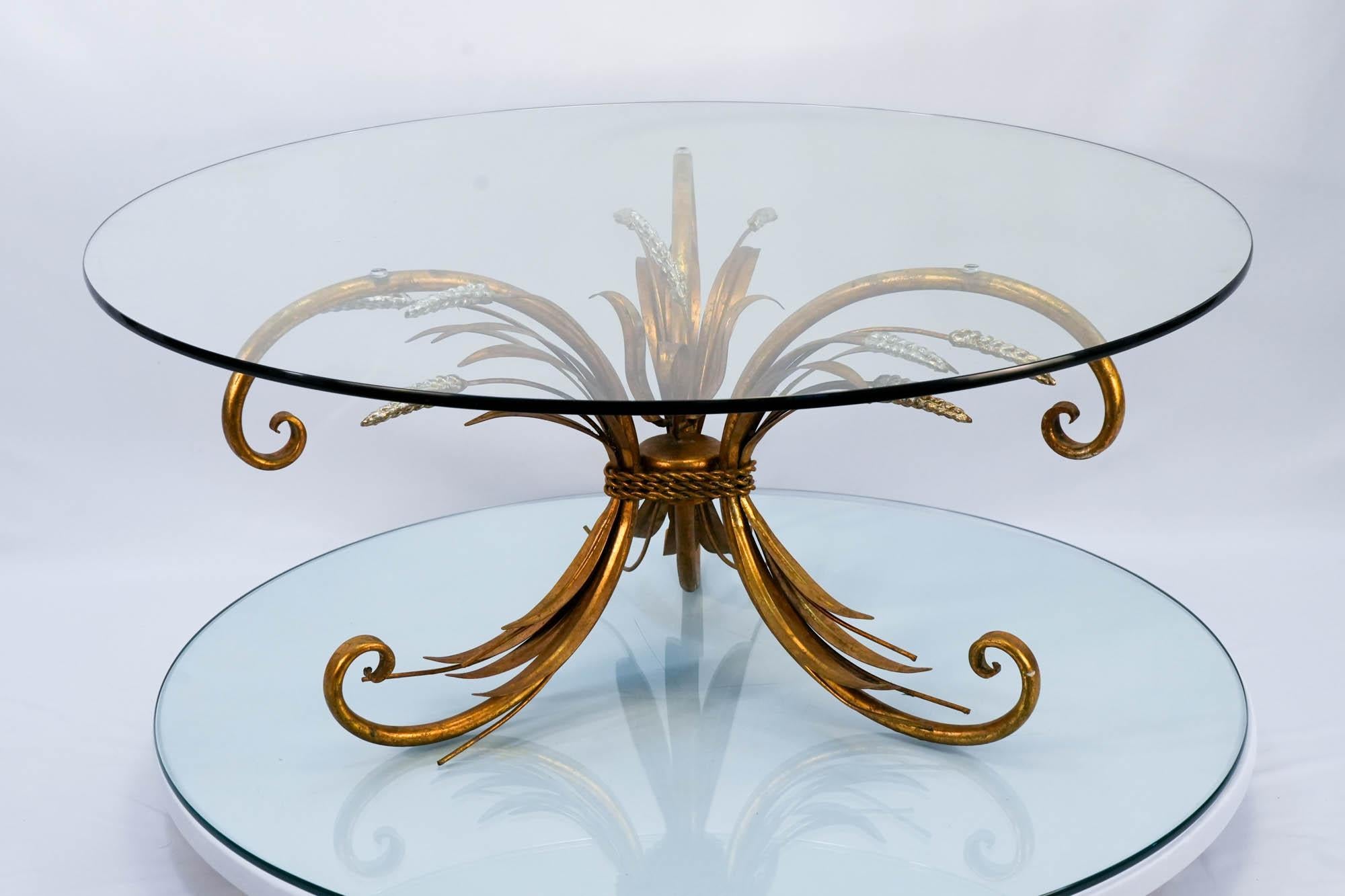 Exprimez une élégance intemporelle et un charme vintage avec cette remarquable table basse sculpturale en métal doré. 
Il est surmonté d'un plateau rond en verre. 
S'inspirant des pièces emblématiques de Coco Chanel, ce design original présente de