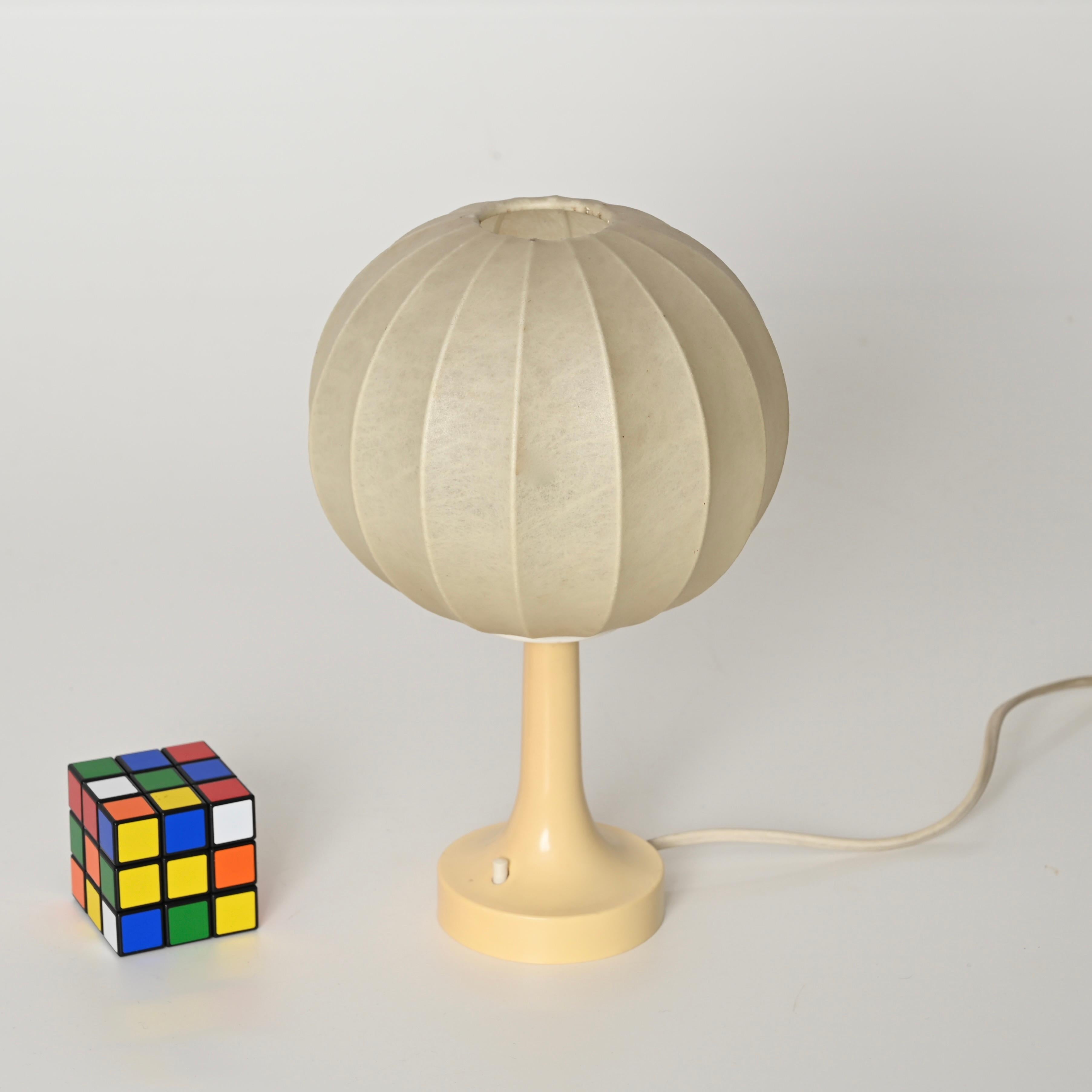 Deliziosa lampada da tavolo a bozzolo del Mid-Century con base in plastica color crema. Questa lampada da tavolo incredibilmente elegante e unica è stata disegnata da Castiglioni e prodotta da Flos in Italia alla fine degli anni Sessanta.

In