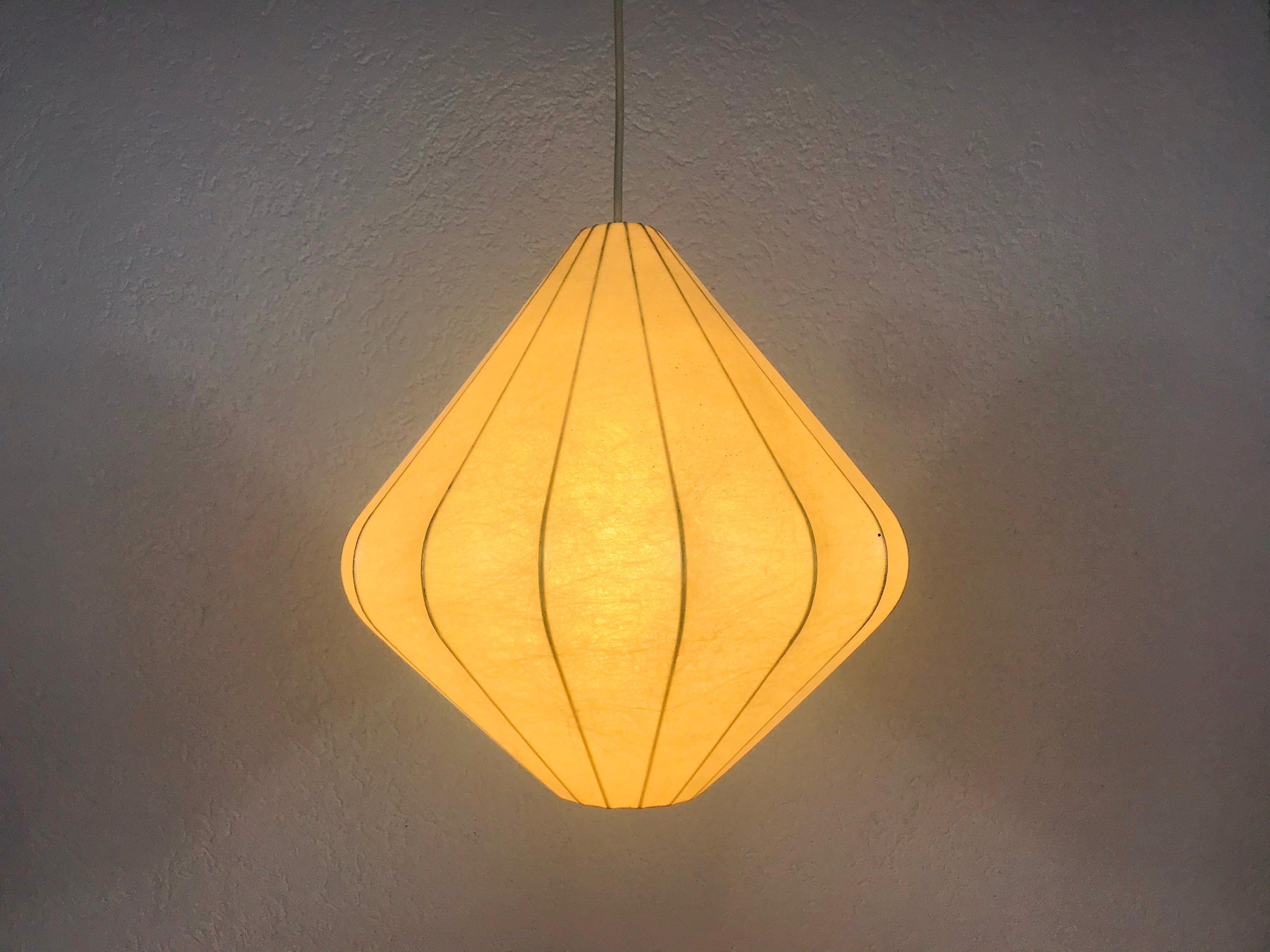 A cocoon pendant lamp made in Italy in the 1960s. The hanging lamp has been designed by Achille Castiglioni. The lamp shade is of original resin and has a flower shape.

The light requires one E27 light bulb.

