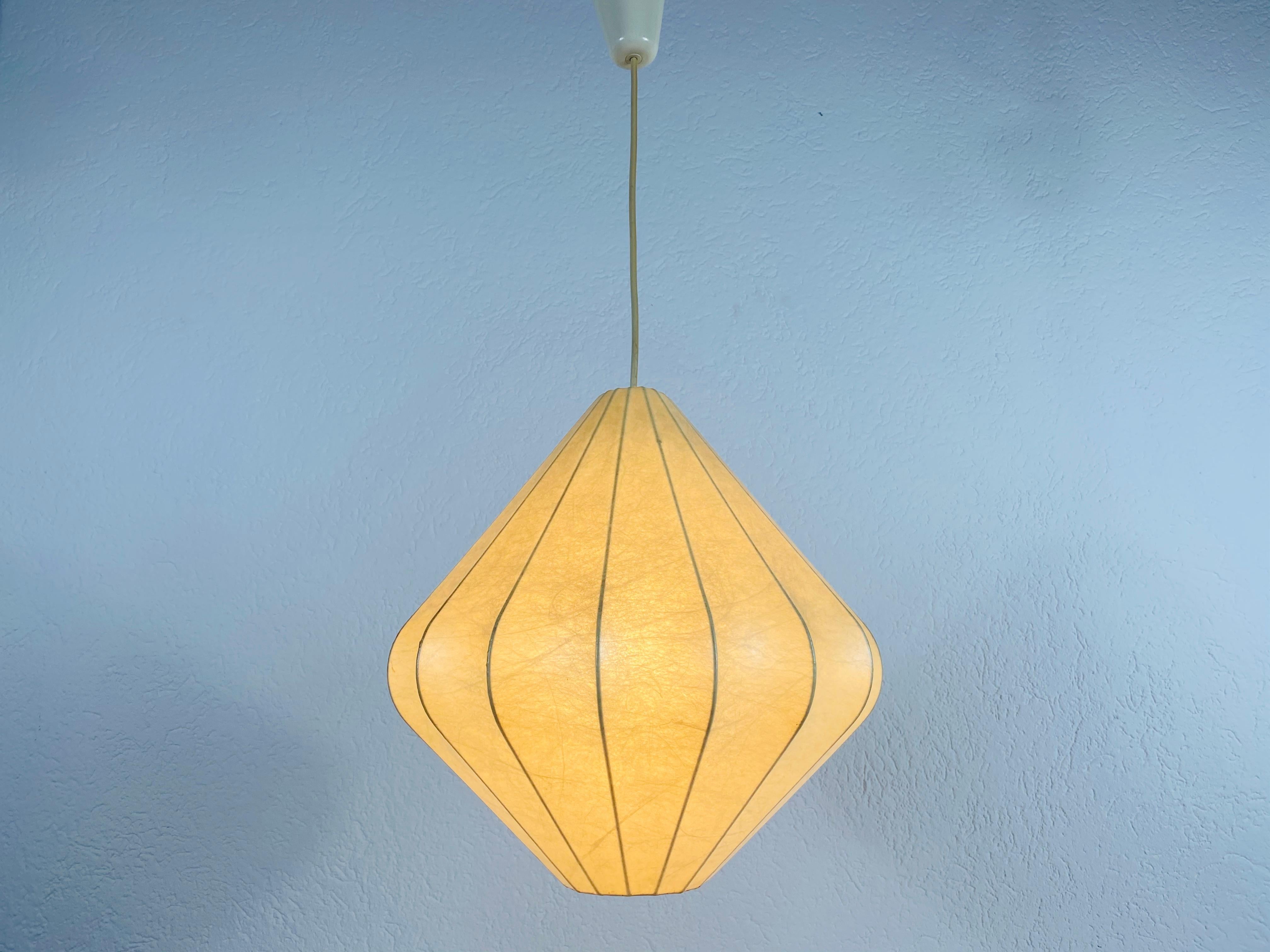 A cocoon pendant lamp made in Italy in the 1960s. The hanging lamp has been designed by Achille Castiglioni. The lamp shade is of original resin and has a flower shape.

Measures: Height 29-70 cm 
Diameter 34 cm

The light requires one E27 (US