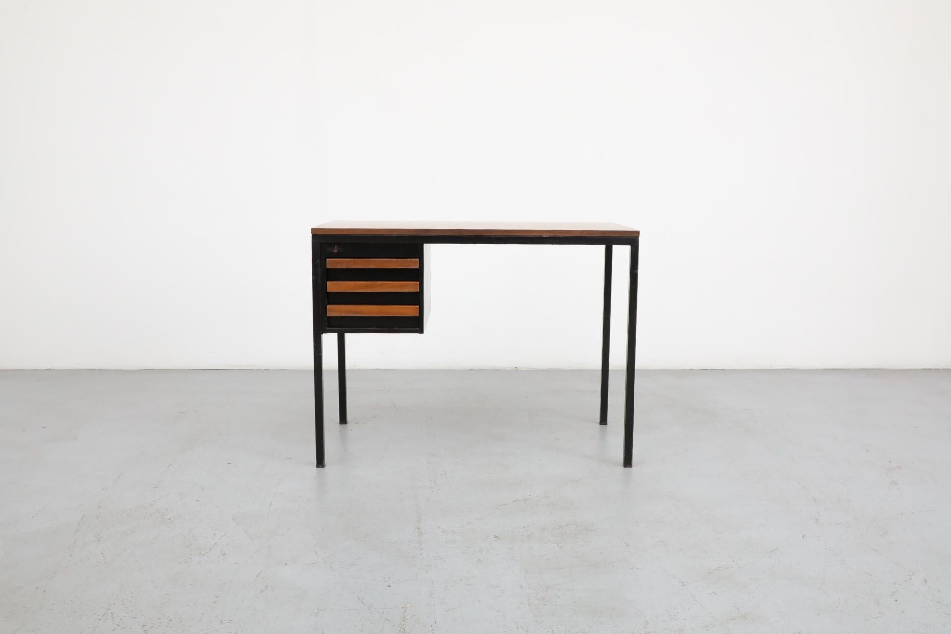 Scrivania o vanità industriale di metà secolo disegnata da Coen de Vries per Emmein Staal. La scrivania ha una serie di cassetti laterali con tiretti in teak, piano in finto noce e struttura in metallo smaltato nero. In condizioni originali con