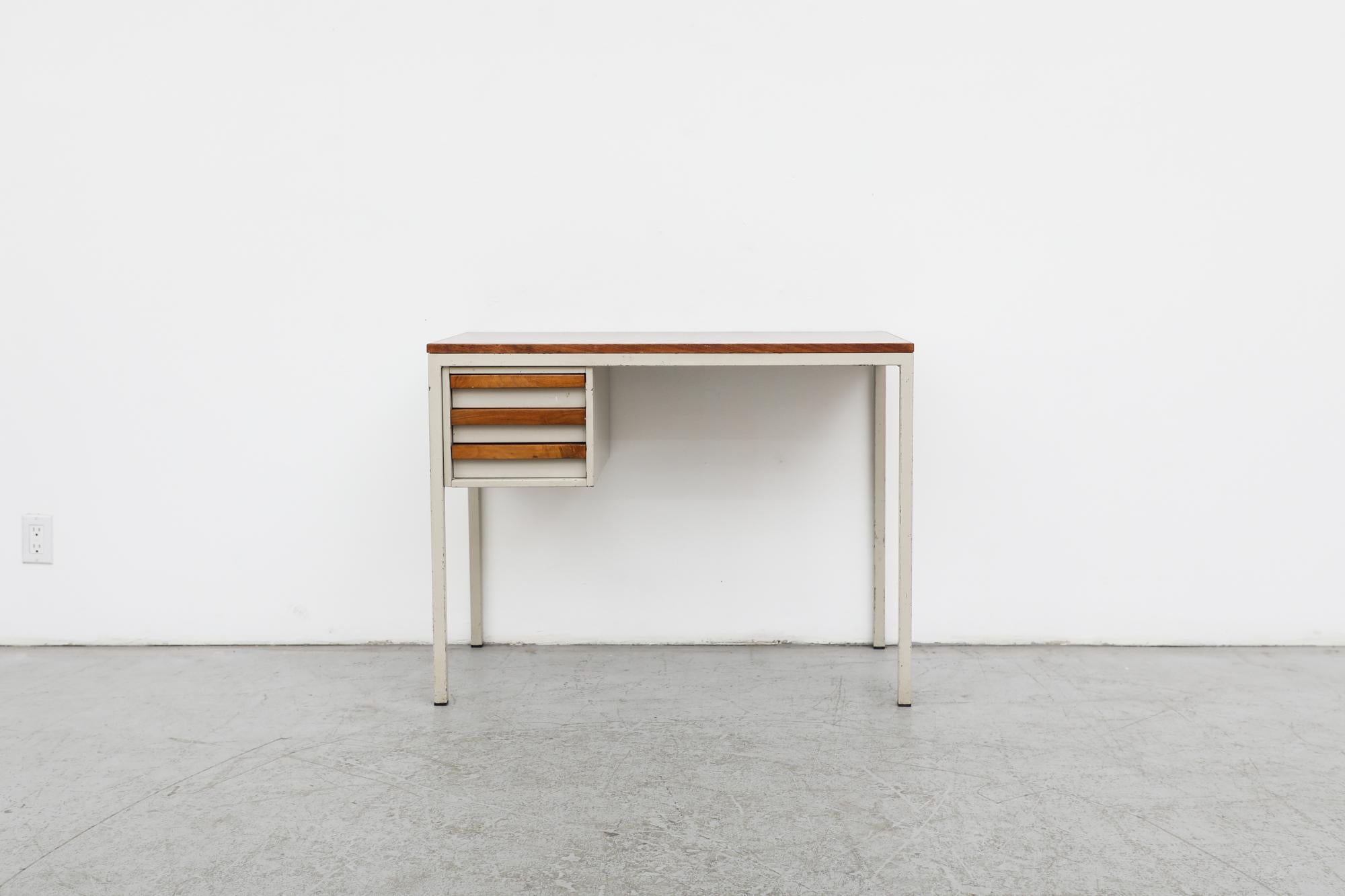 Beautiful Industrial writing desk designed by Coen de Vries for Emmein Staal. Grey eneameld metal frame with one set of side drawers and wooden top with wood accents. In original condition with wear consistent with age and use. Similar desks also