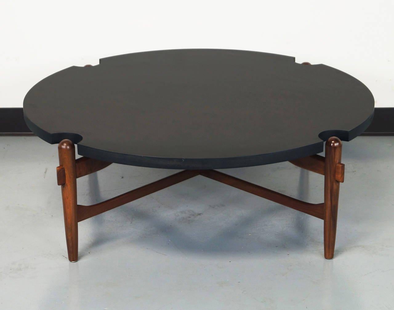 Midcentury cocktail/coffee table designed by well known California modernist Greta Grossman, circa 1950, having a laminate circular top with demilune reserves exposing the walnut tapered legs conjoined with the thru Tenon double X-stretcher.