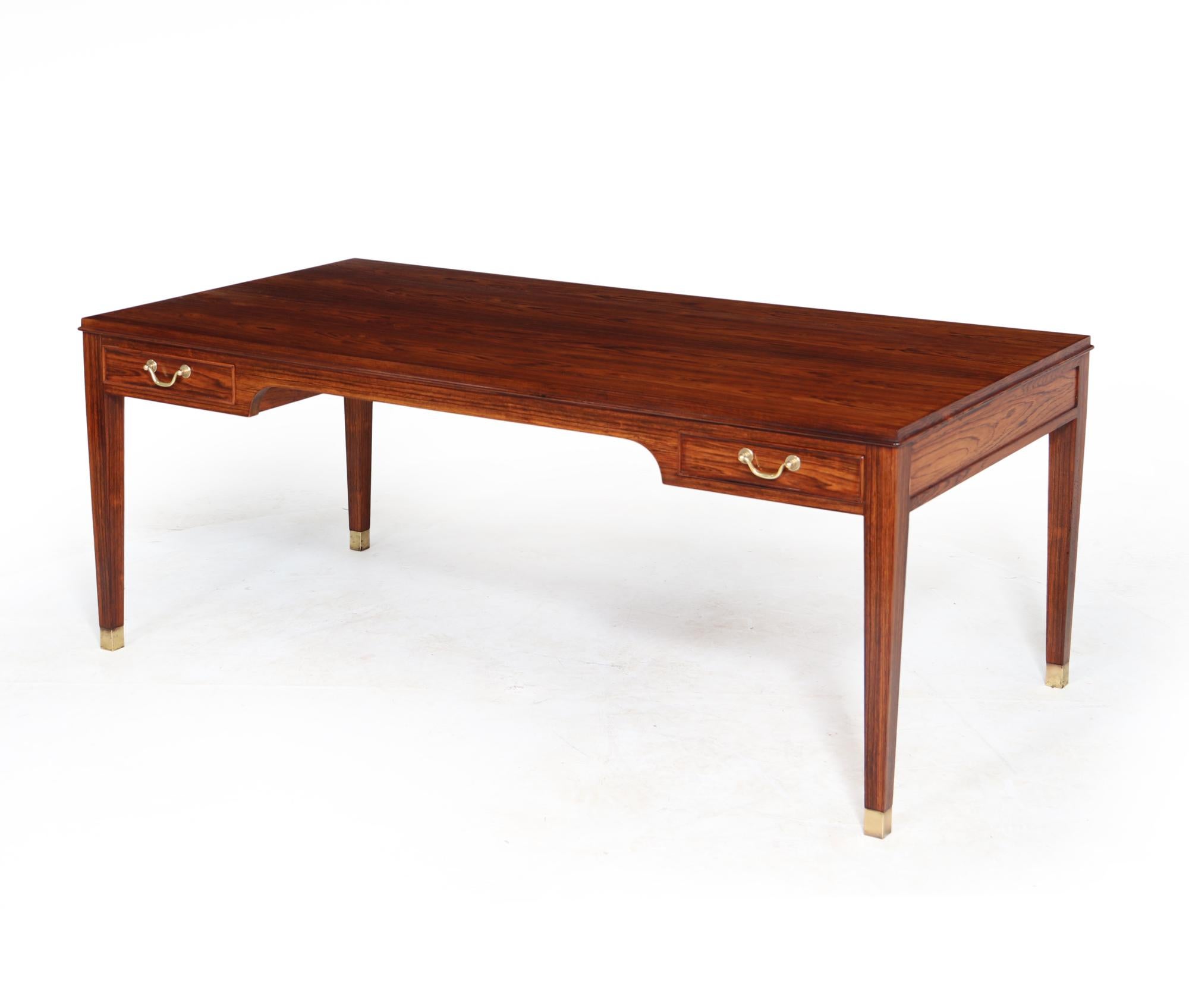 A mid century Rosewood coffee table produced in Denmark in the 1950s and designed by Fritz Henningson the table has four drawers with brass swan neck handles and sabots, the table is super quality and has been carefully restored and hand polished