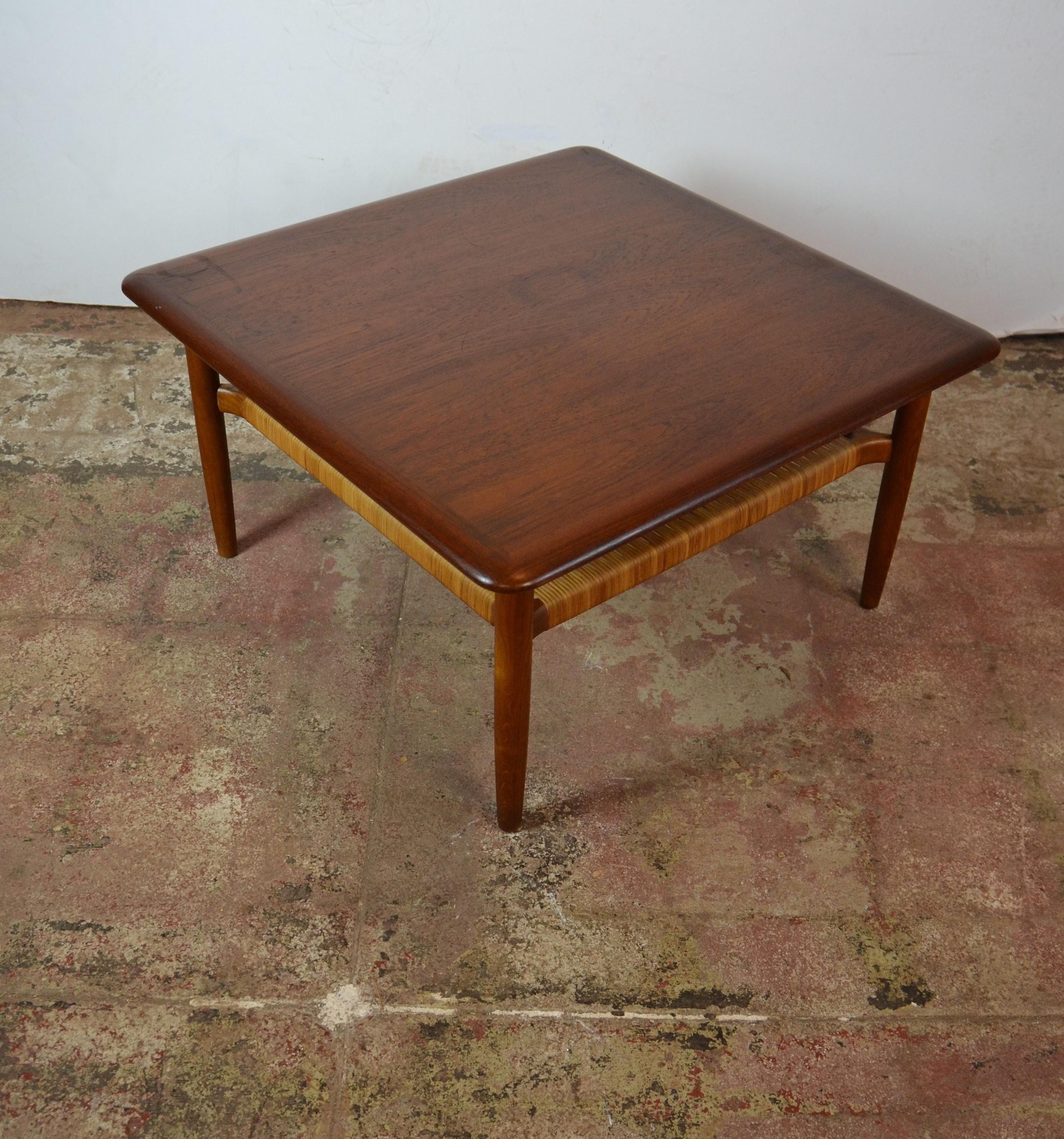 Midcentury coffee table by Gunnar Schwartz. Teak wood with woven cane undershelf.