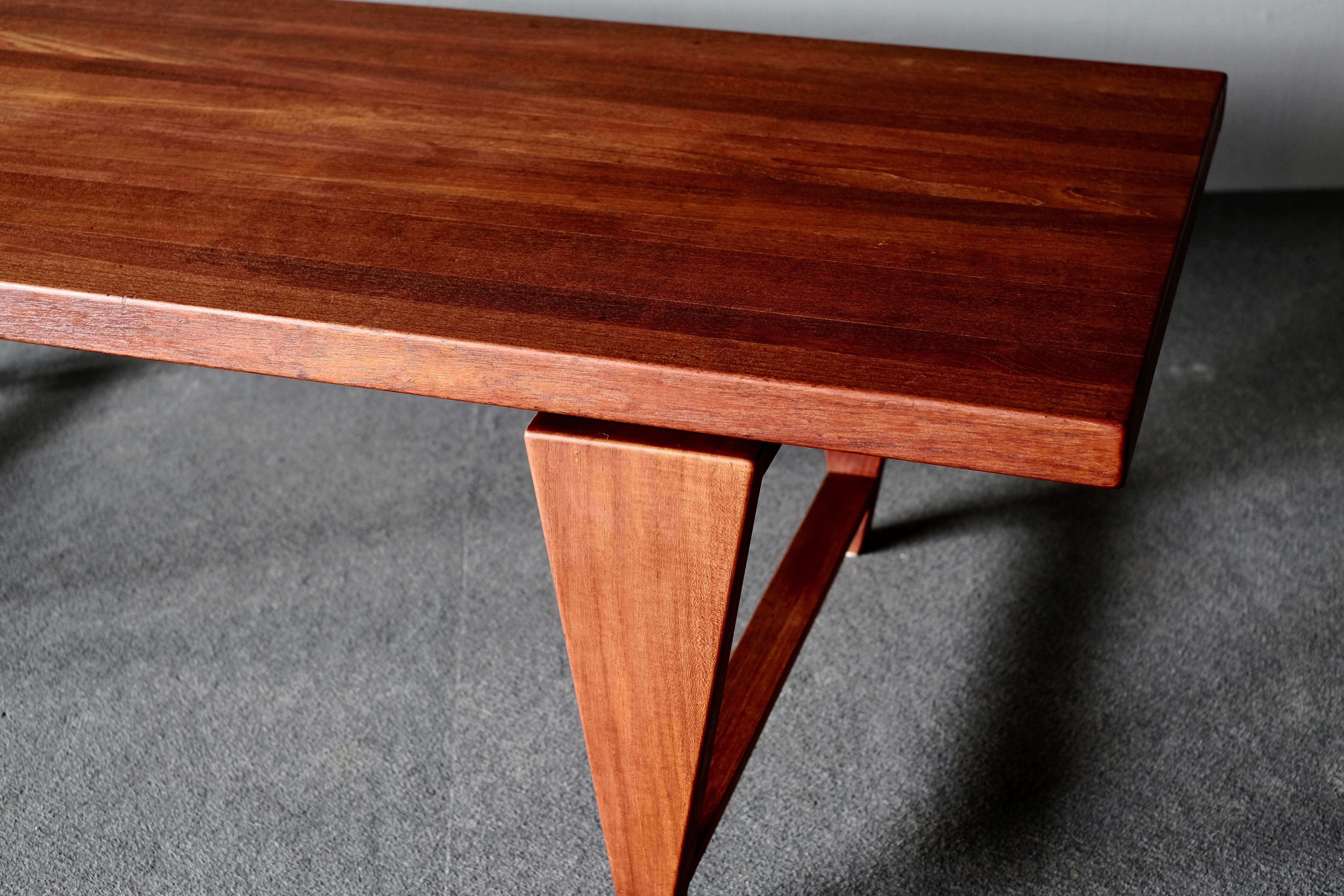 Coffee table by Illum Wikkelsø, manufactured by Mikael Laursen. This is in solid beautifully patinated teak and has the signature Wikkelsø inverted pyramid legs. The unusual details make the tabletop look like its hovering above its base.