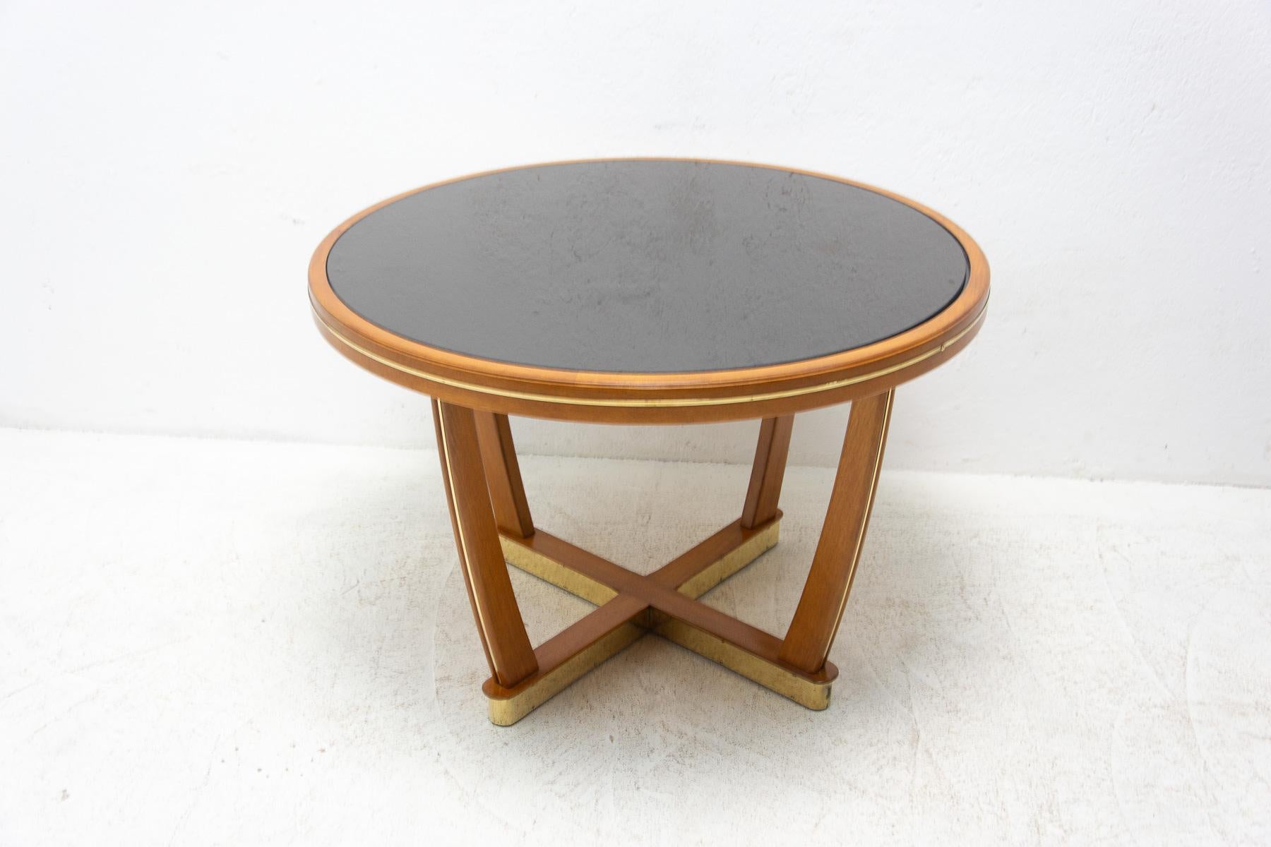 Mid-century coffee table, made by Ilse Möbel in Germany in the 1950's.

Made of beech wood, brass, black glass on the top.

In very good condition, fully renovated.

Measures: height 60 cm, diameter 90 cm.